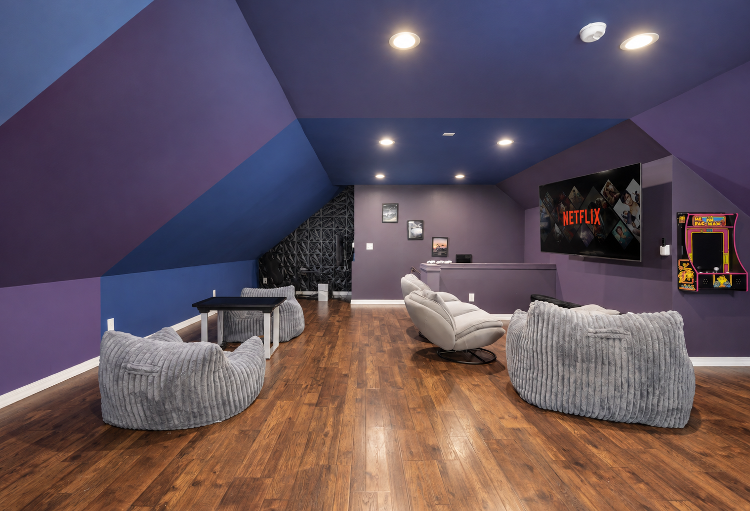 Loft game room with big-screen TV, arcade fun, and cozy lounge seating