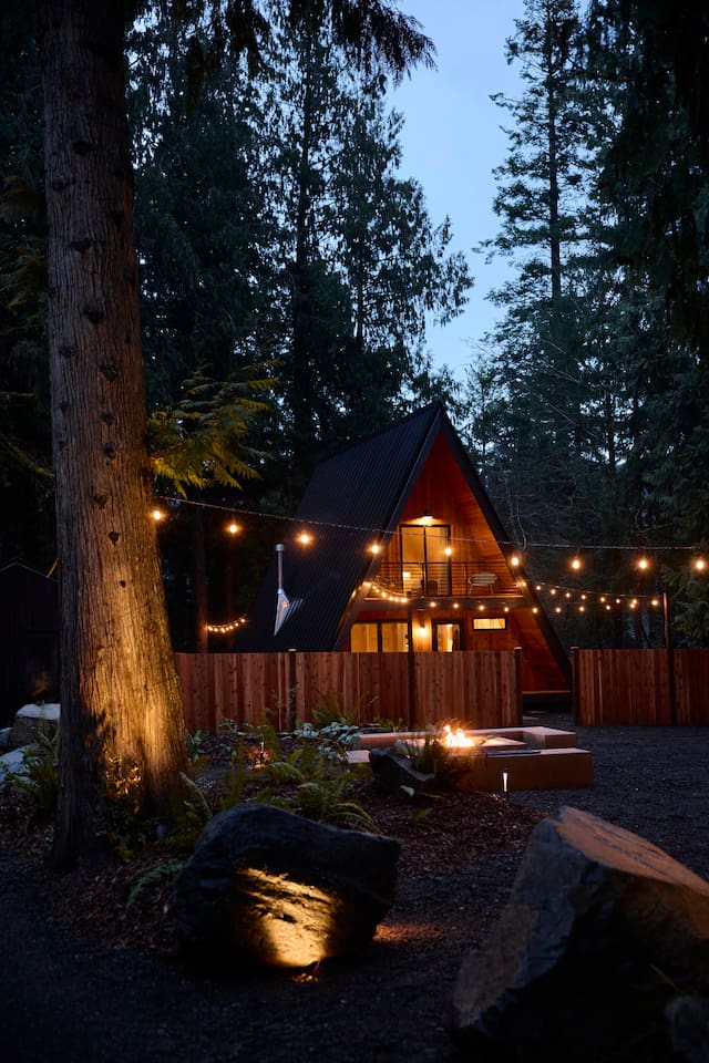 Living area with soaring A-frame glass and warm light