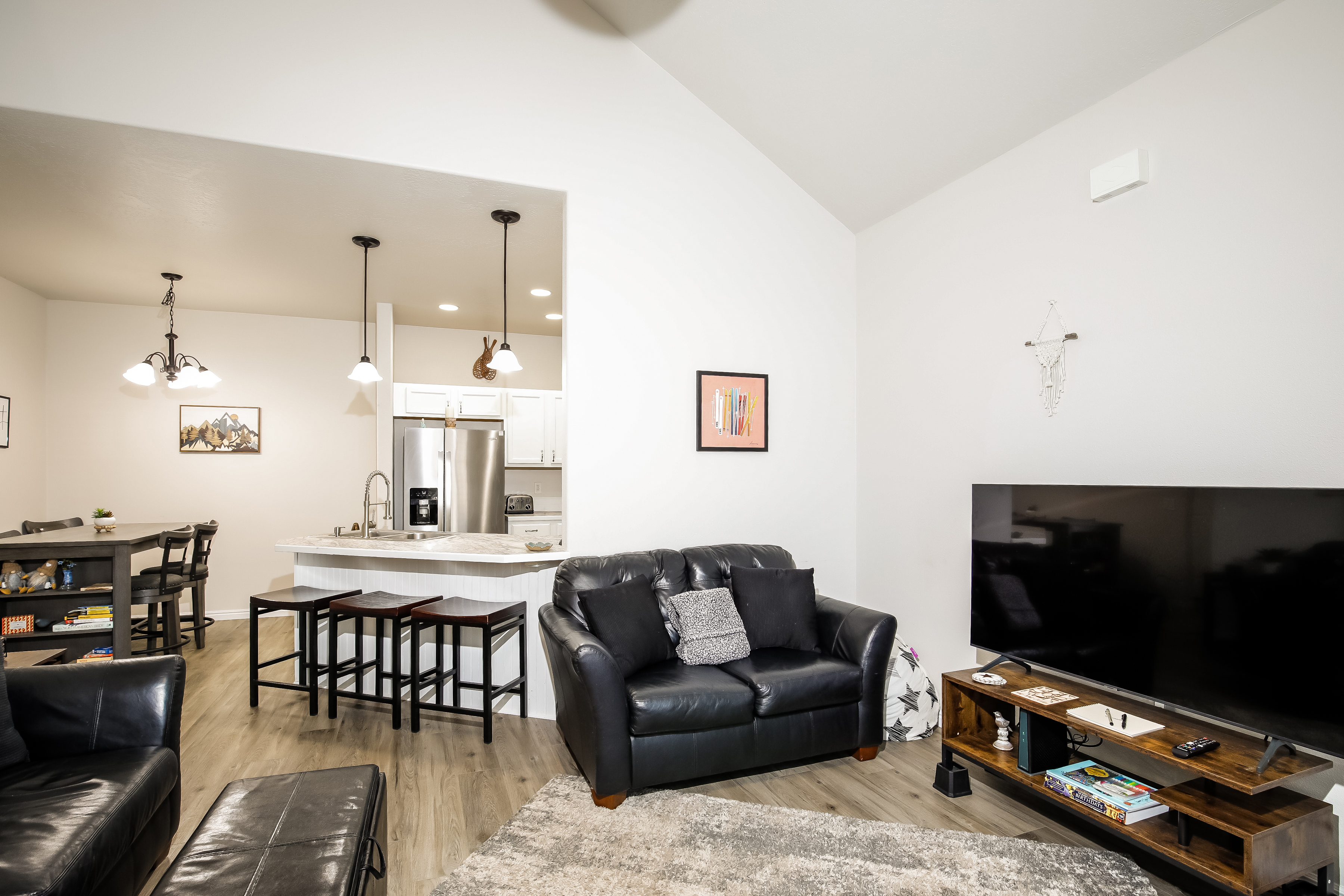 Bright open-plan lounge with leather sofas, island kitchen & big TV