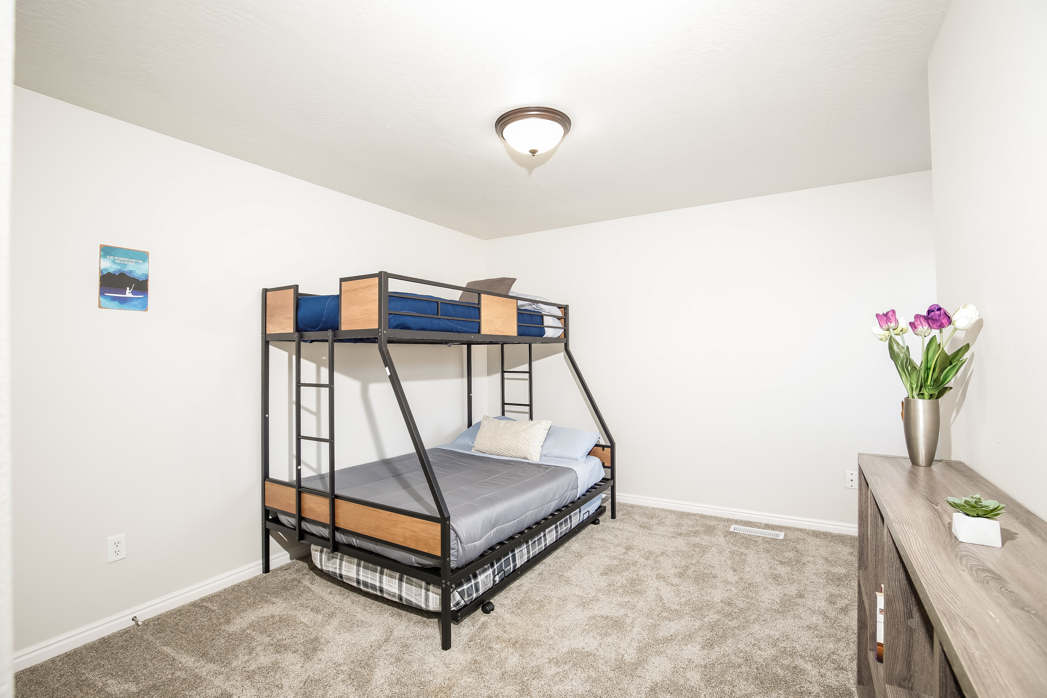 Bright bunk room with twin-over-full bed, plush carpet, family-ready.