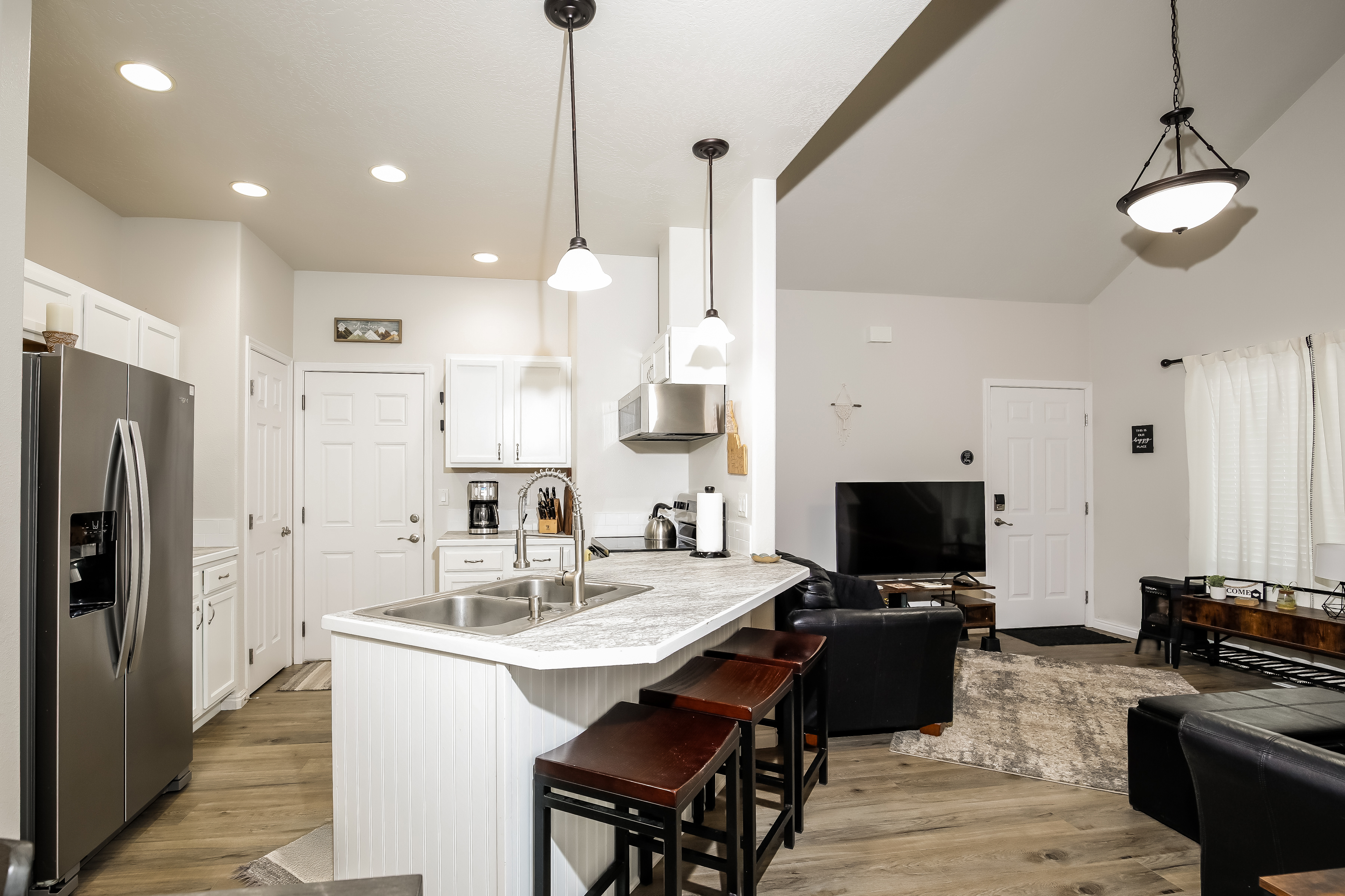 Bright open kitchen-living with bar seating, stainless, vaulted ceilings.