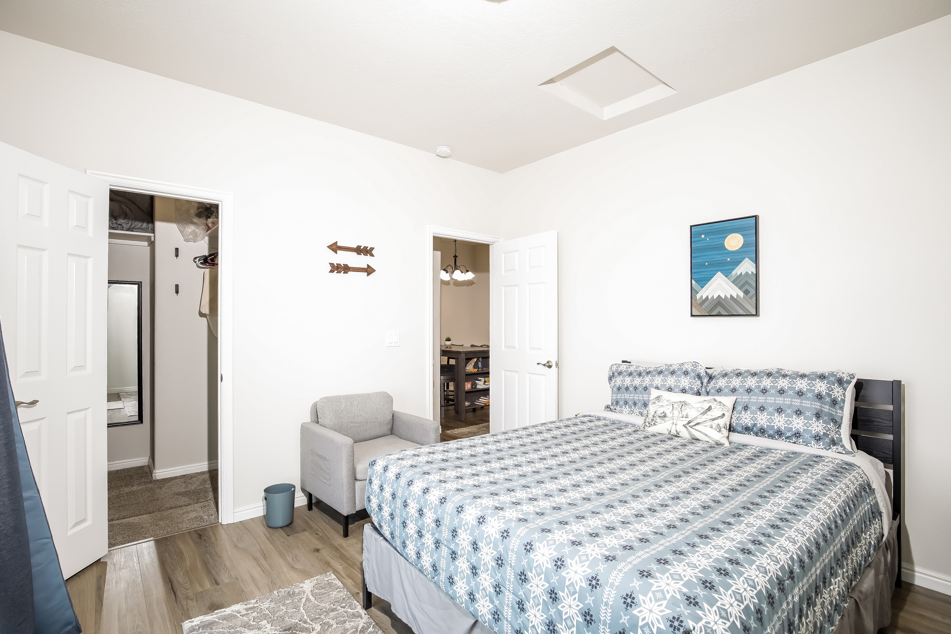 Sunny bedroom with queen bed, closet, and comfy chair