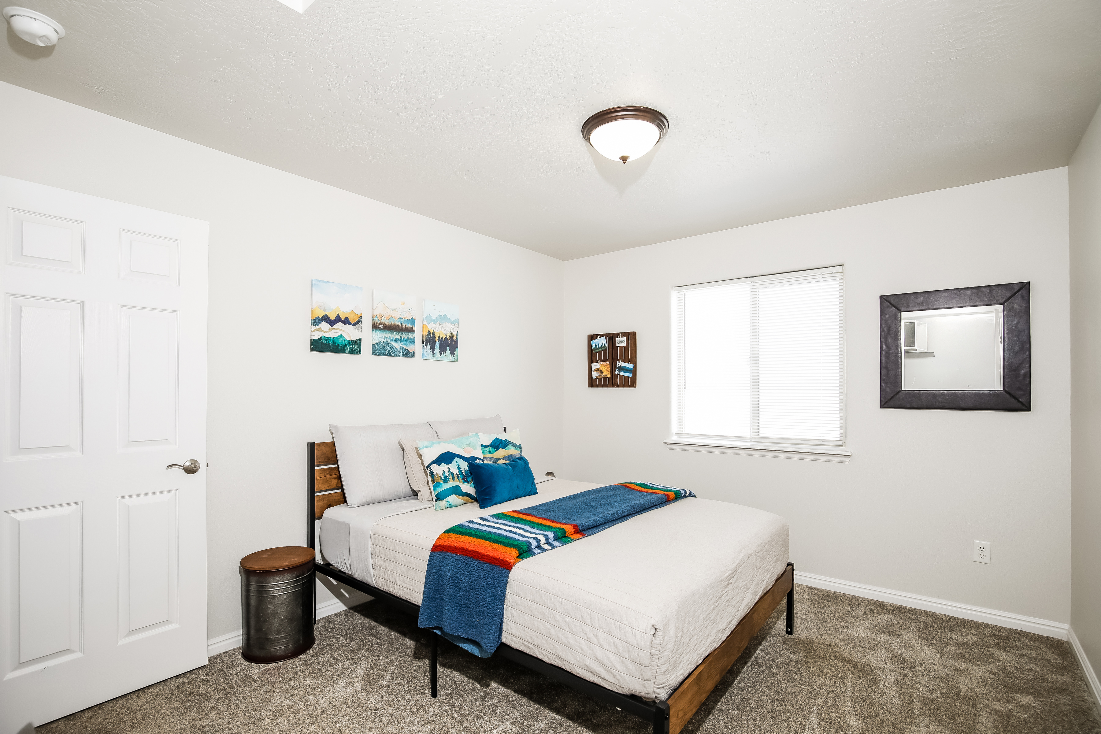 Bright, cozy bedroom with plush carpet and colorful accents