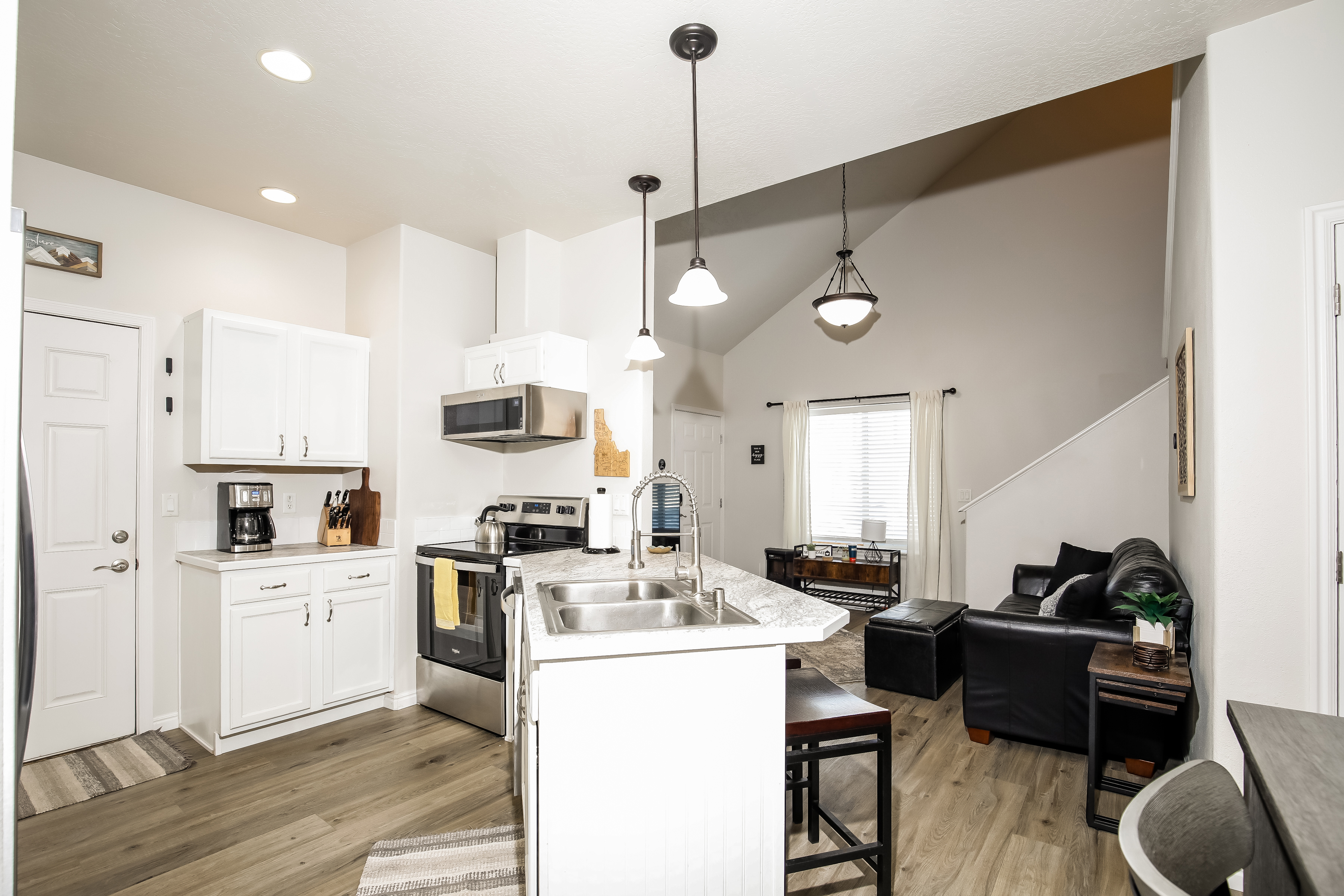 Bright open kitchen & lounge with island seating and vaulted ceilings