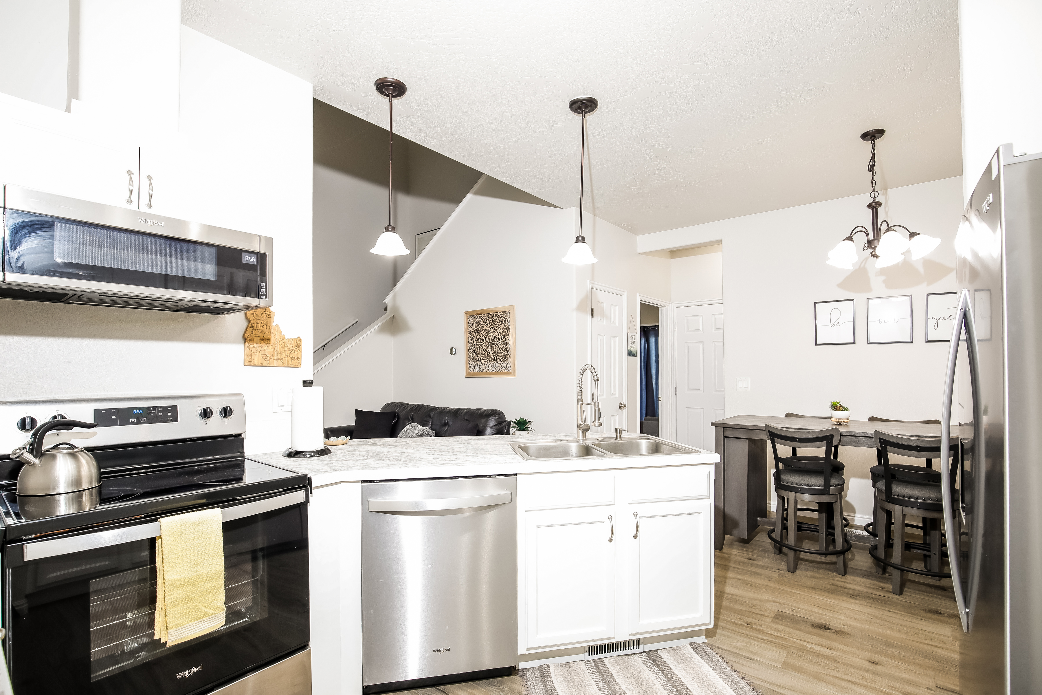 Airy kitchen with stainless appliances, island sink & cozy dining