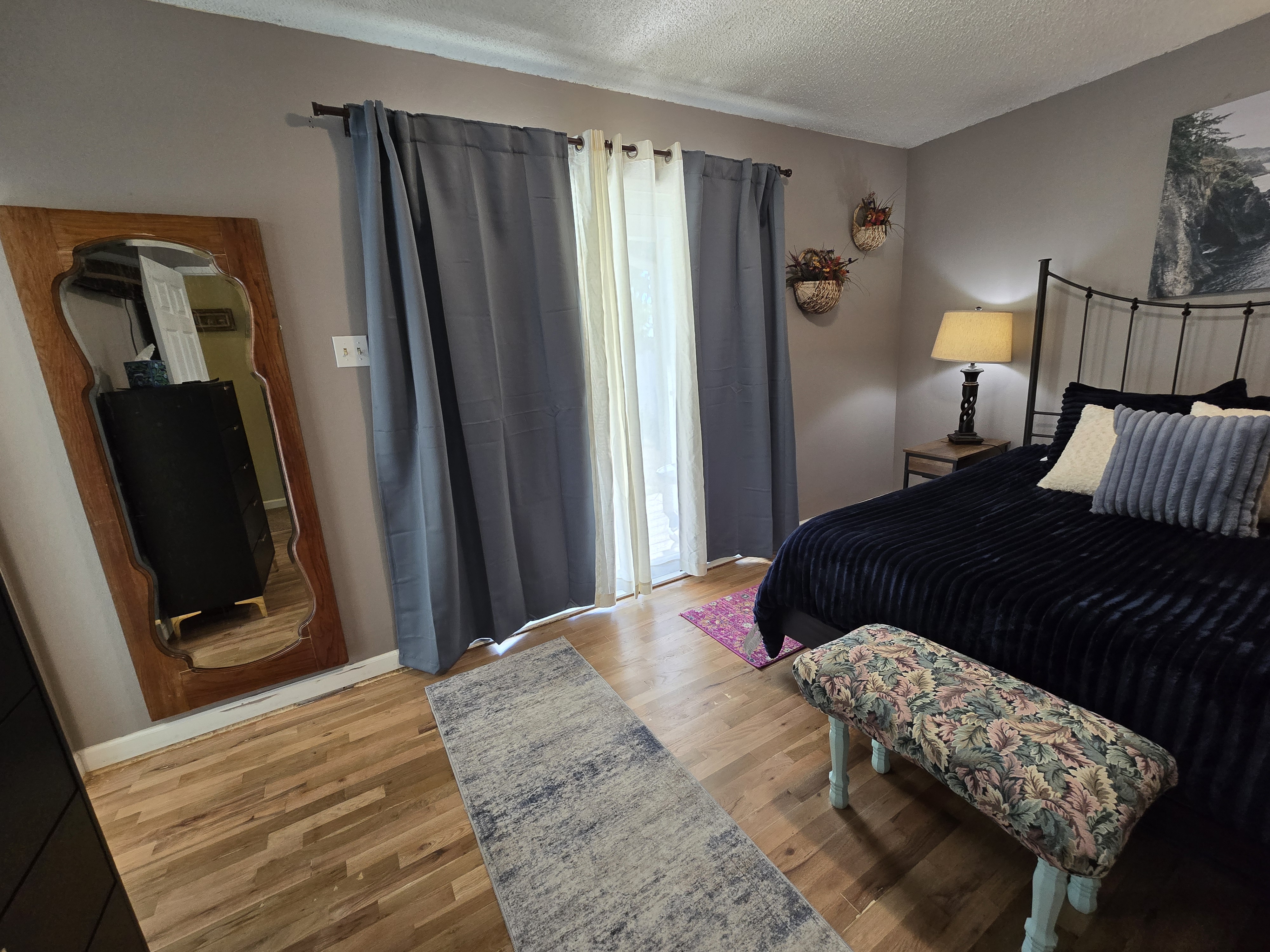 Cozy bedroom with hardwood floors, soft lighting, and stylish decor