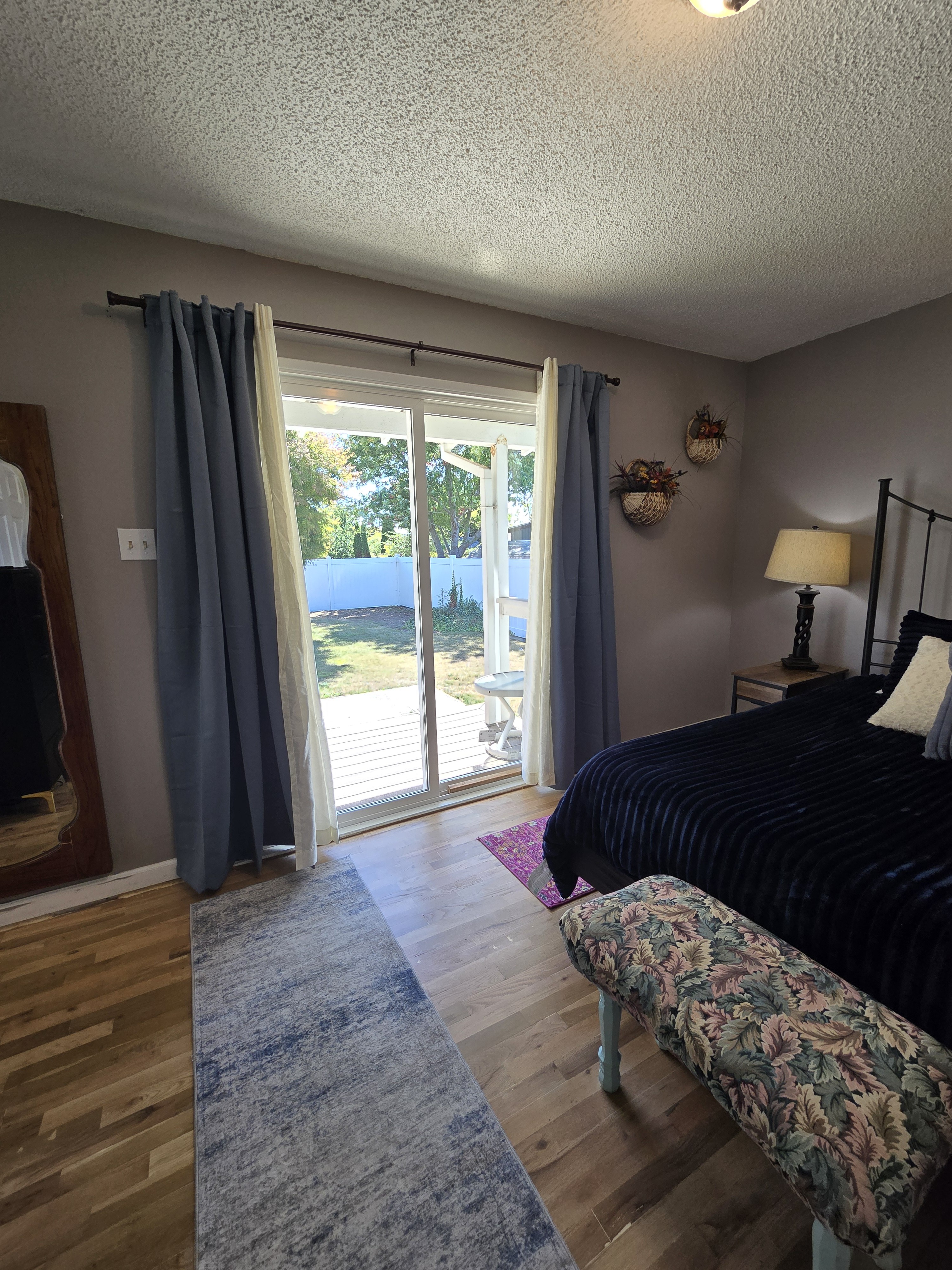 Bright, cozy bedroom with large window and peaceful yard views