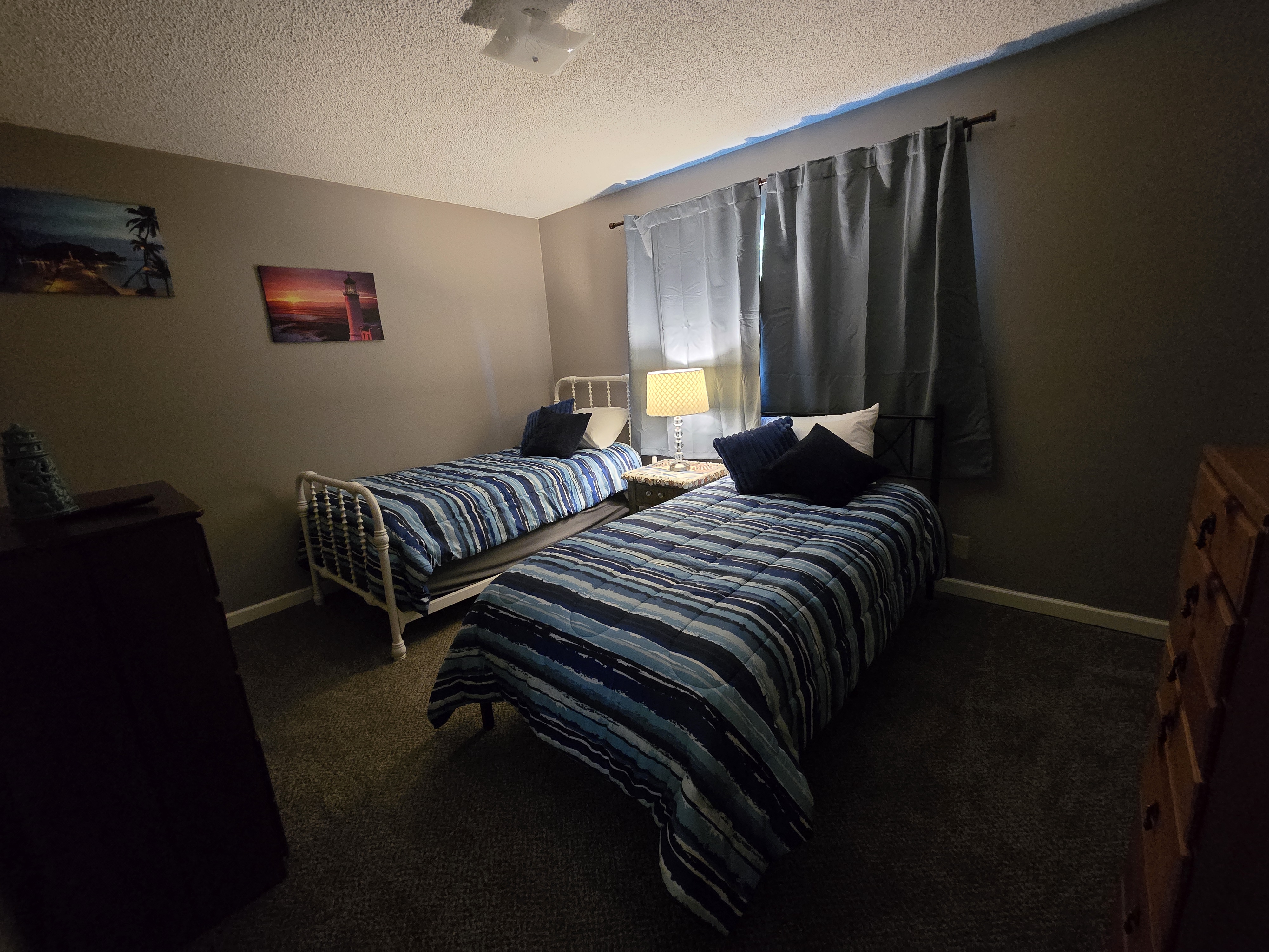 Cozy twin bedroom with soft lighting, storage, and guest-friendly comfort