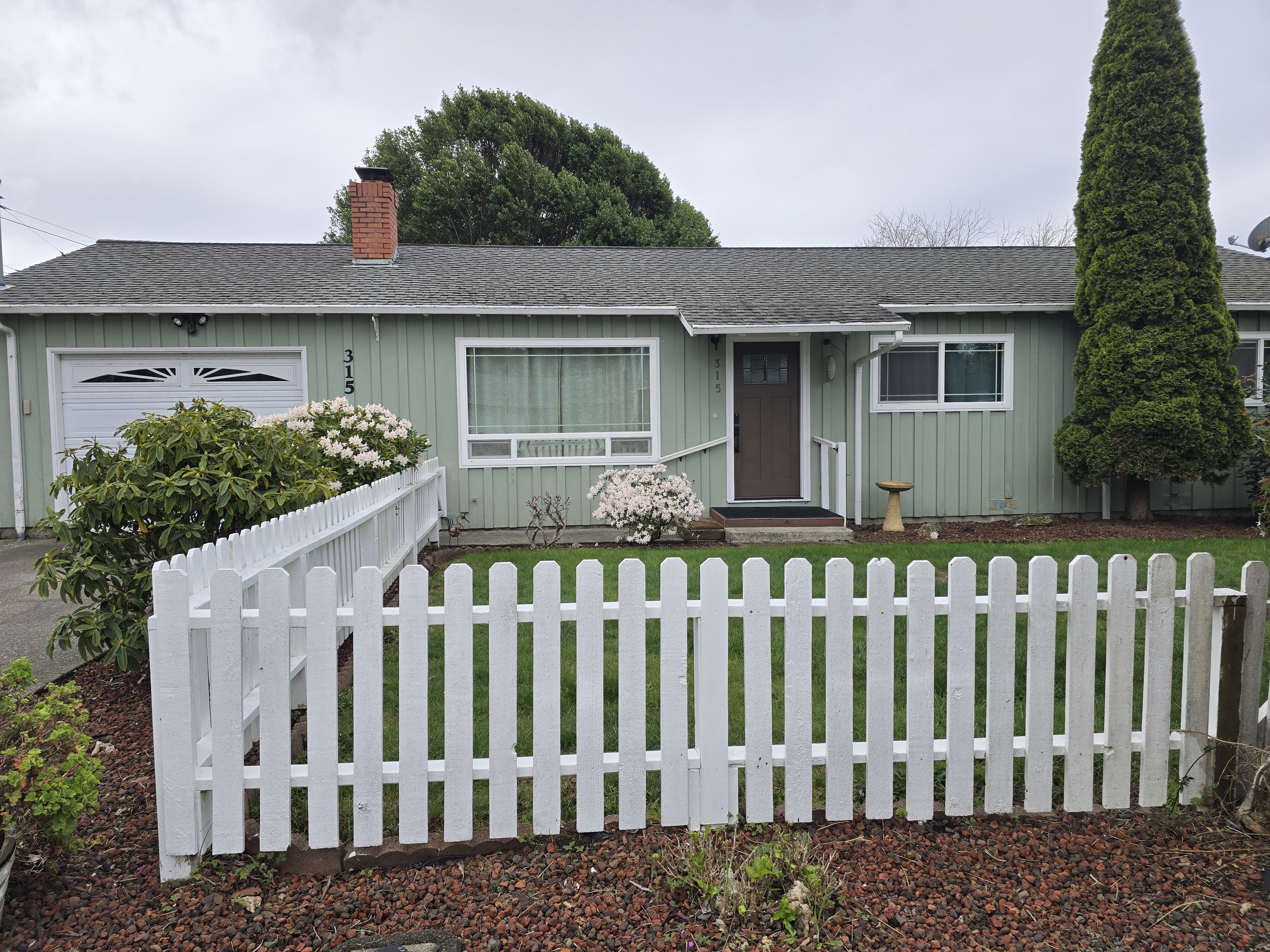 Charming cottage-style home with white picket fence and inviting curb appeal