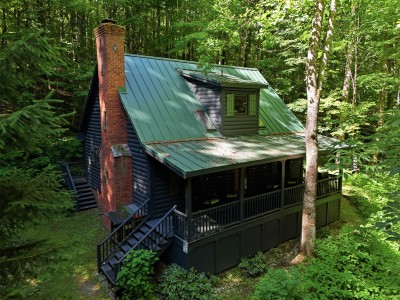 Secluded forest cabin with covered porch and charming rustic appeal