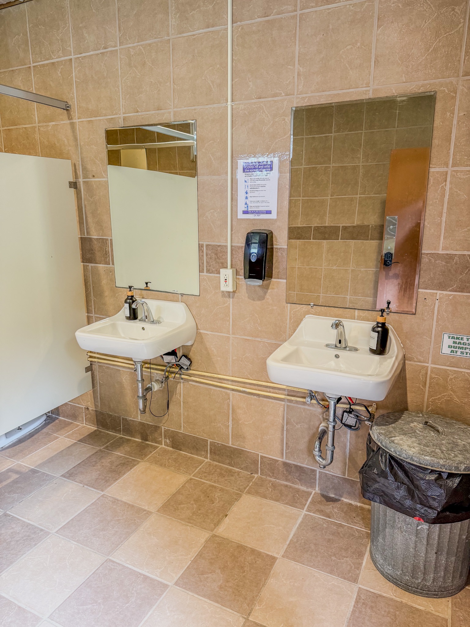 Clean shared bathroom with double sinks and neutral tiled finish