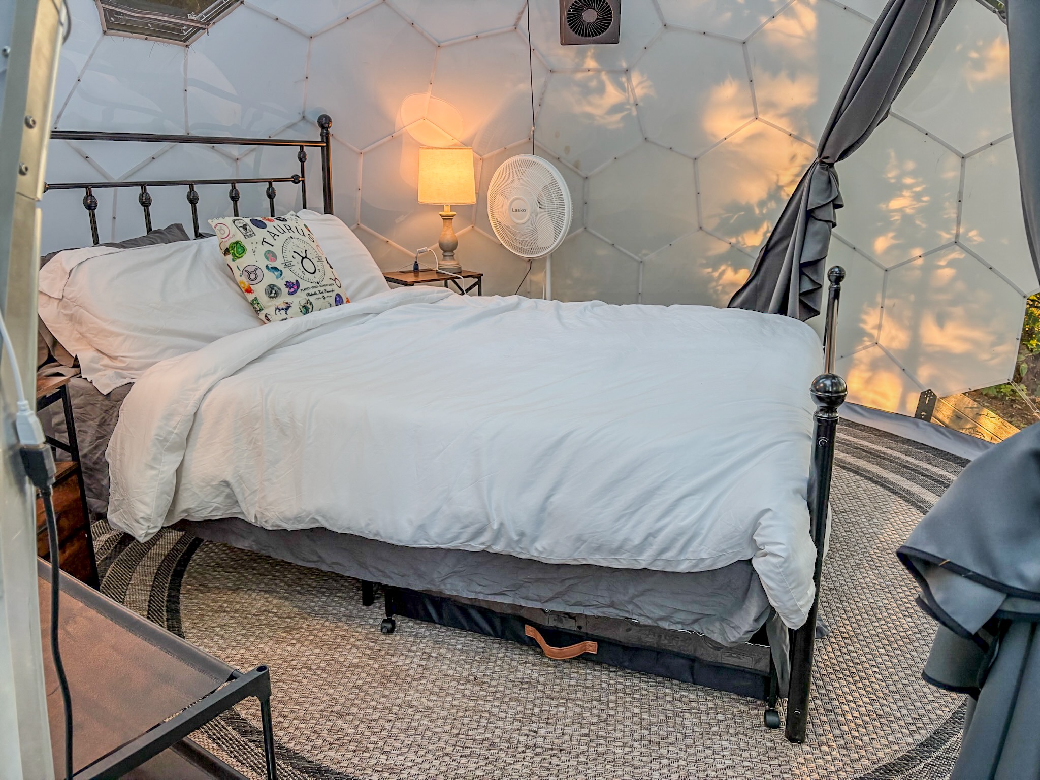 Cozy dome retreat with plush bedding, soft light, and inviting glamping charm