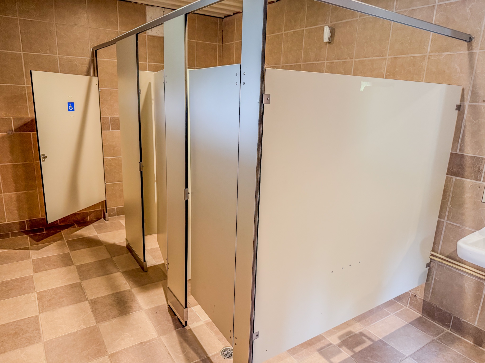 Clean, spacious restroom with private stalls and accessible features