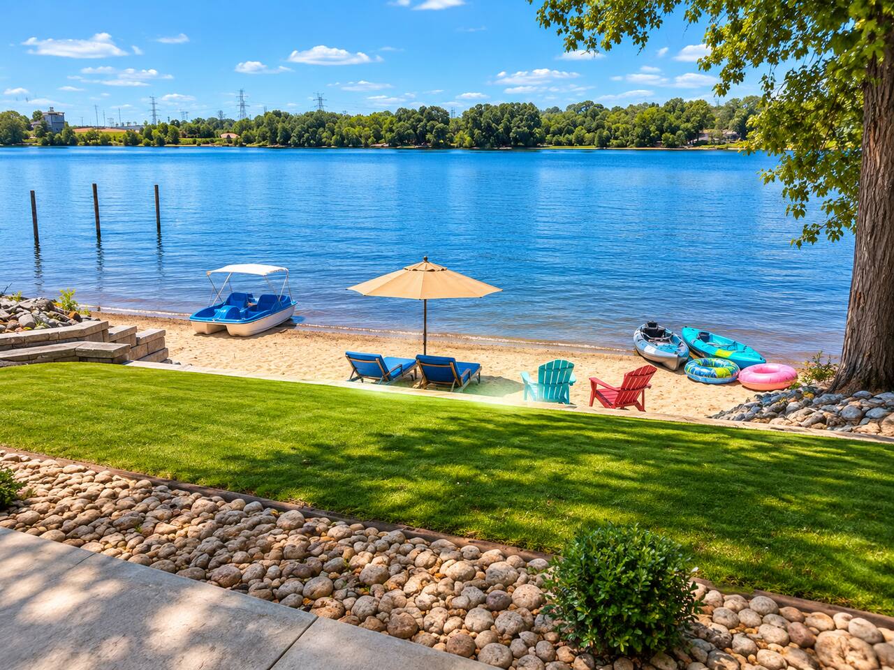 Private lakeside beach with calm water views, kayaks, and manicured grounds