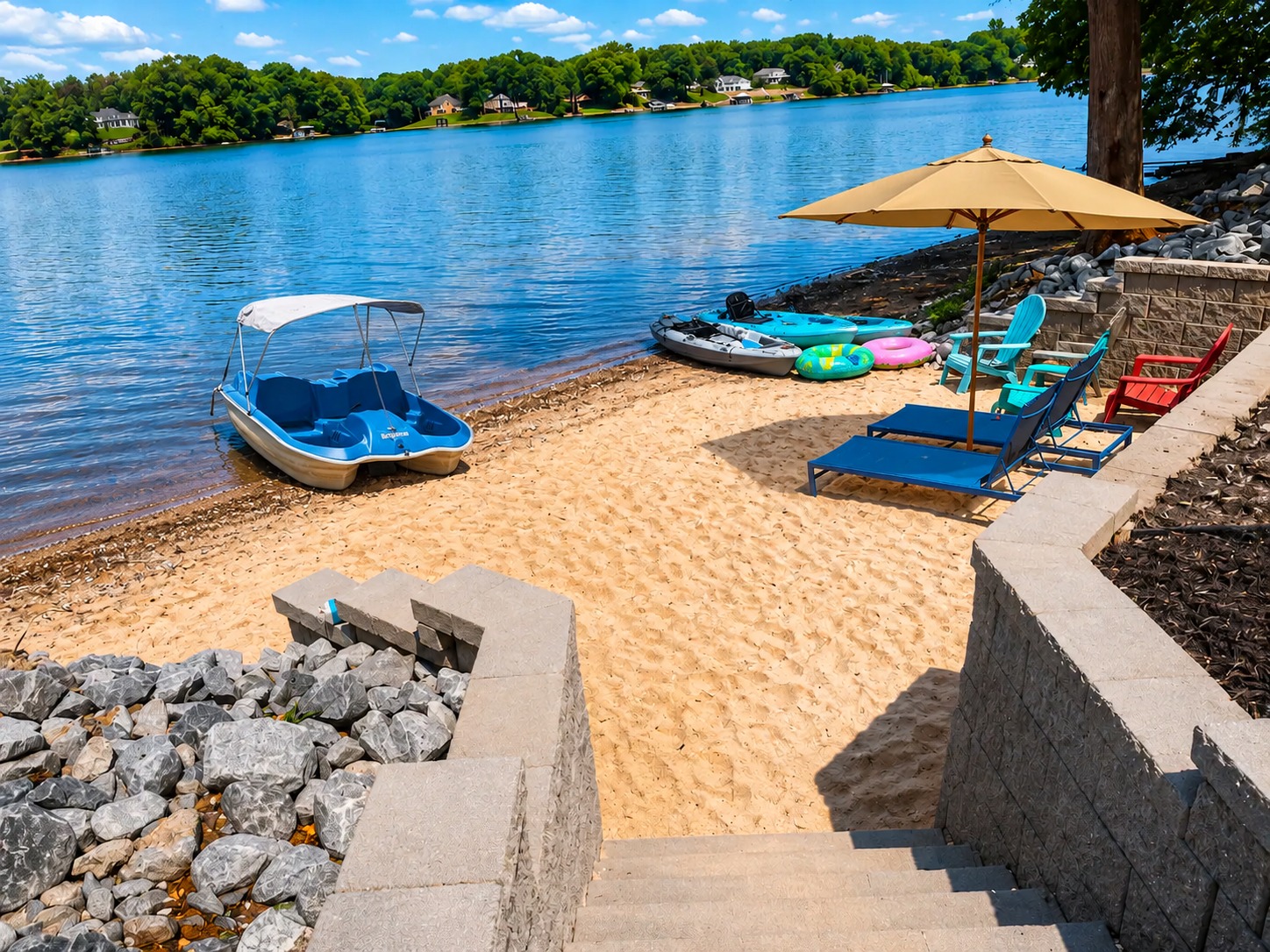 Private sandy lake beach with loungers, kayaks, and serene water views
