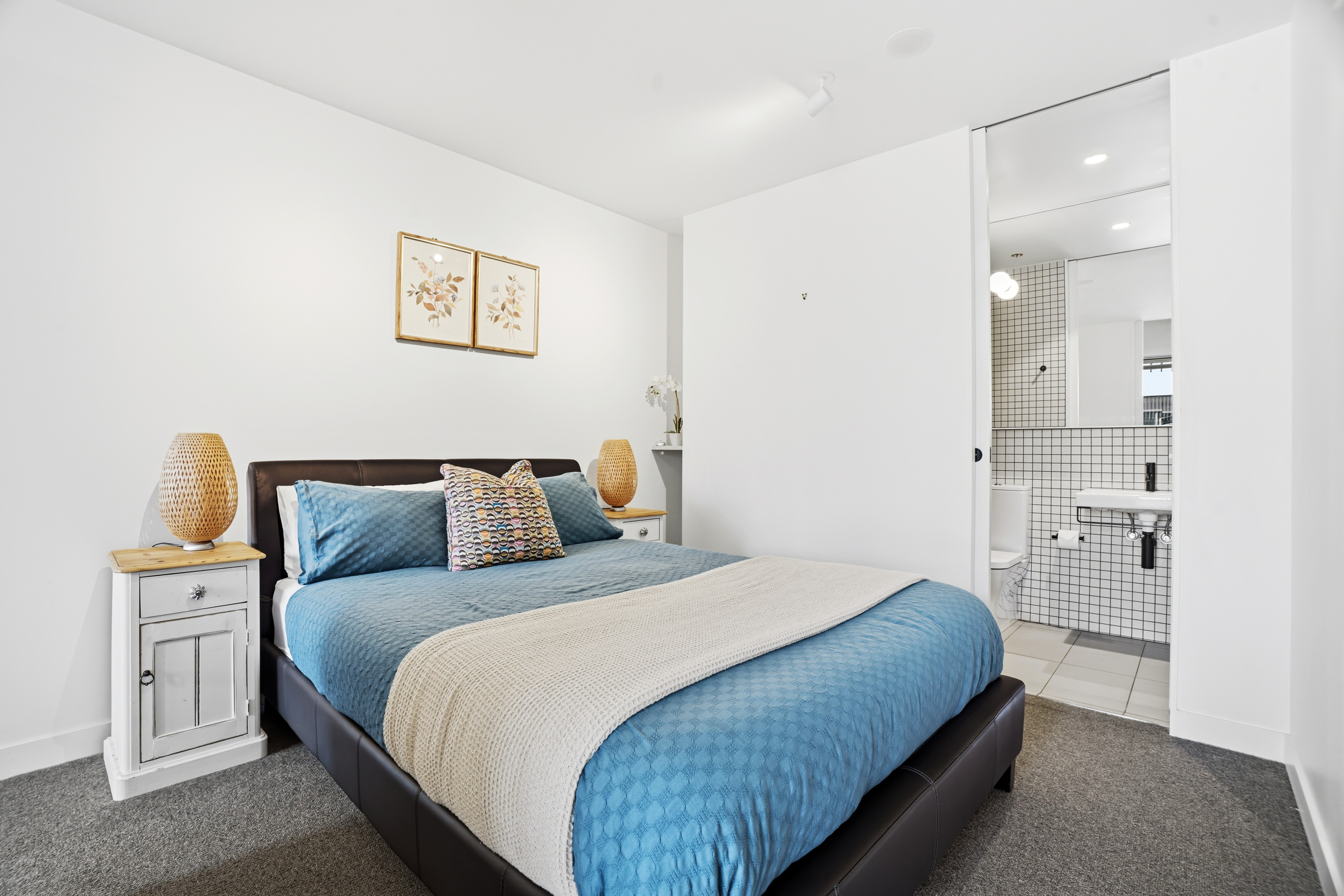 Bright modern bedroom with stylish ensuite and cozy blue bedding
