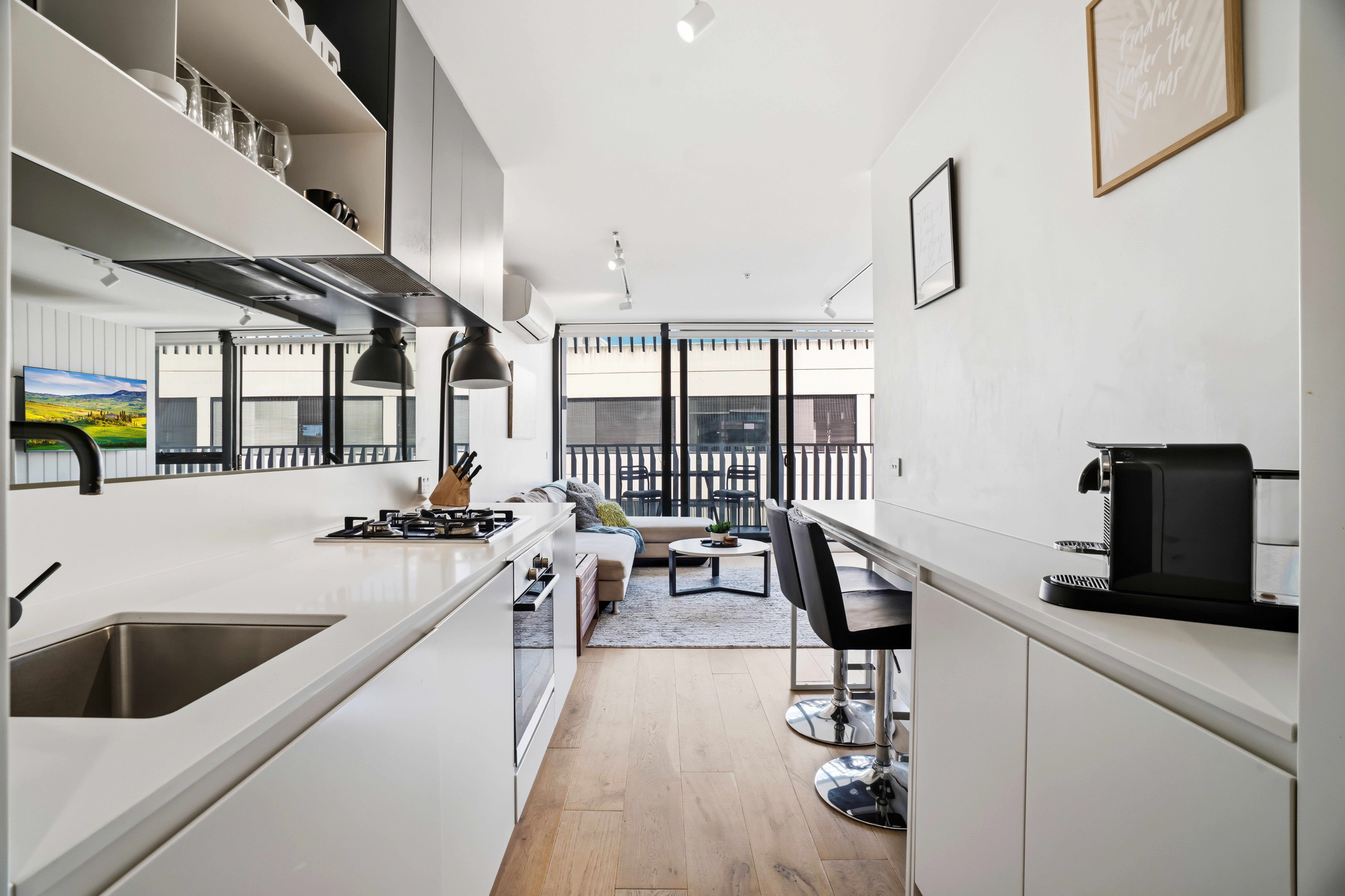 Bright modern apartment with sleek kitchen, bar seating, and balcony views