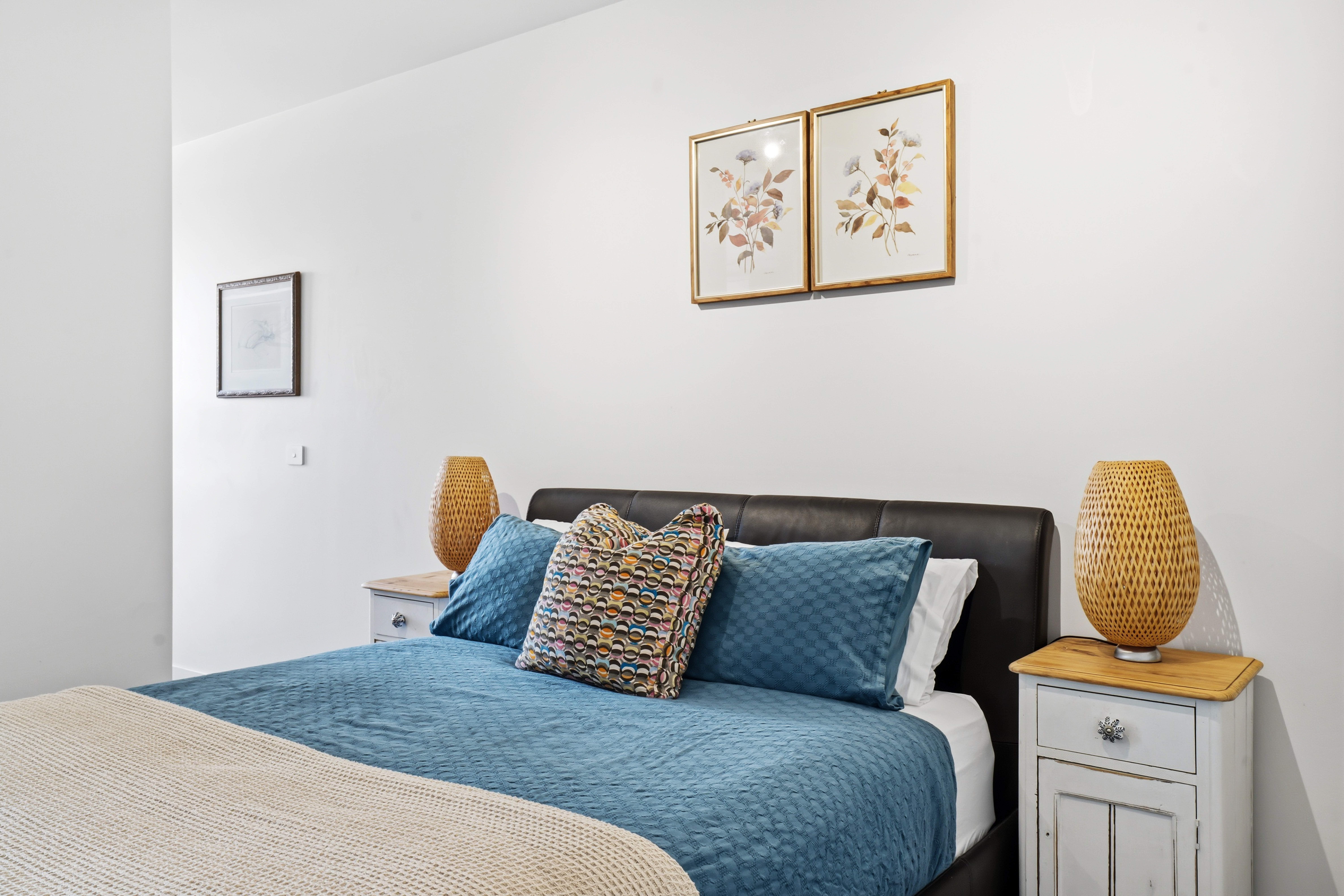 Bright, stylish bedroom with plush blue bedding and warm modern accents