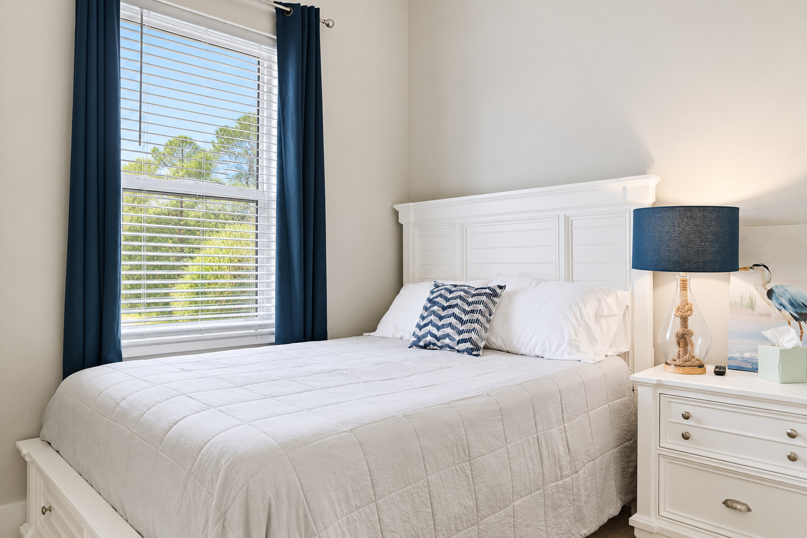 Bright coastal-style bedroom with natural light and crisp white furnishings