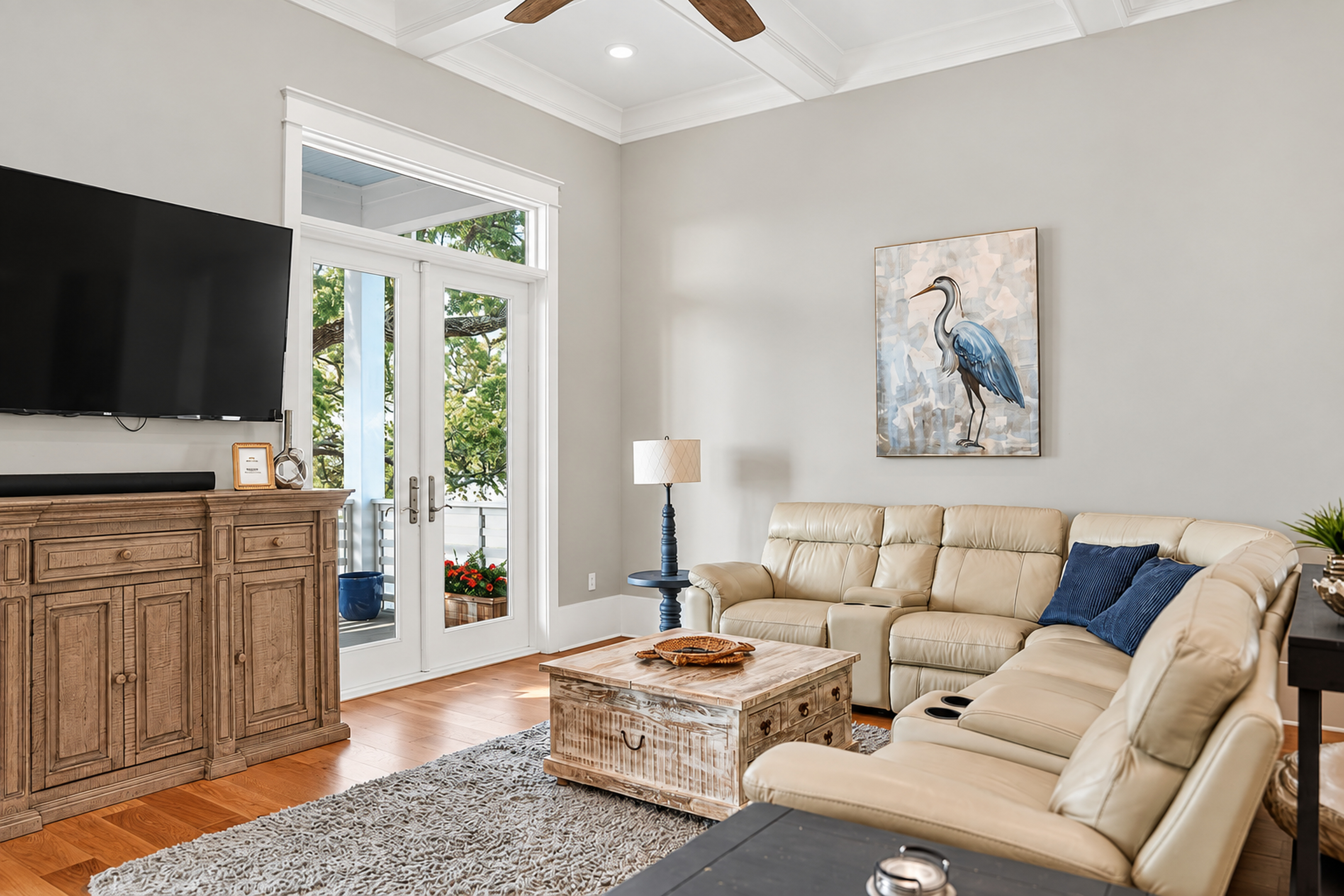 Bright living room with sectional seating, TV, and sunny French doors