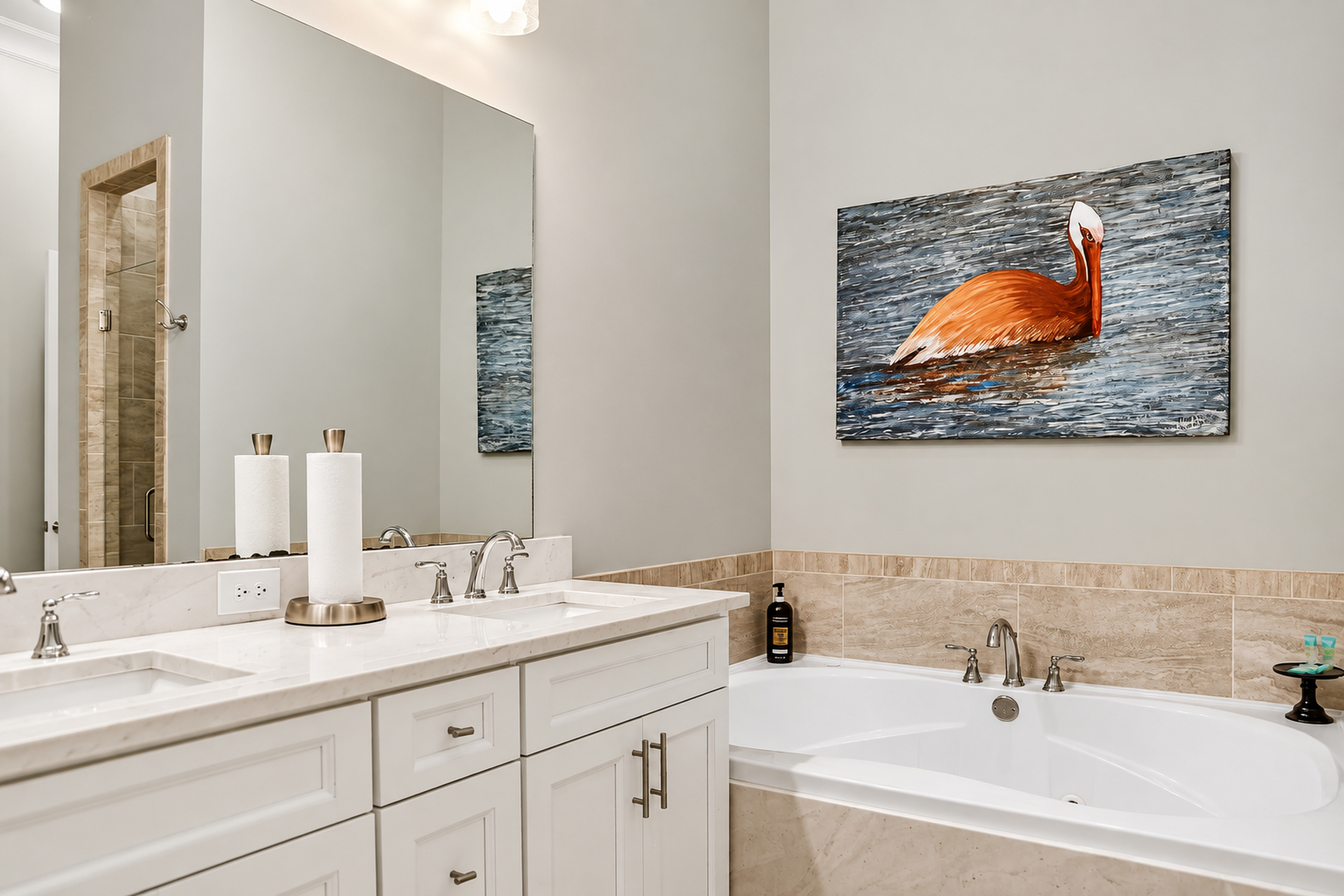 Spa-style bathroom with double vanity, soaking tub, and coastal art