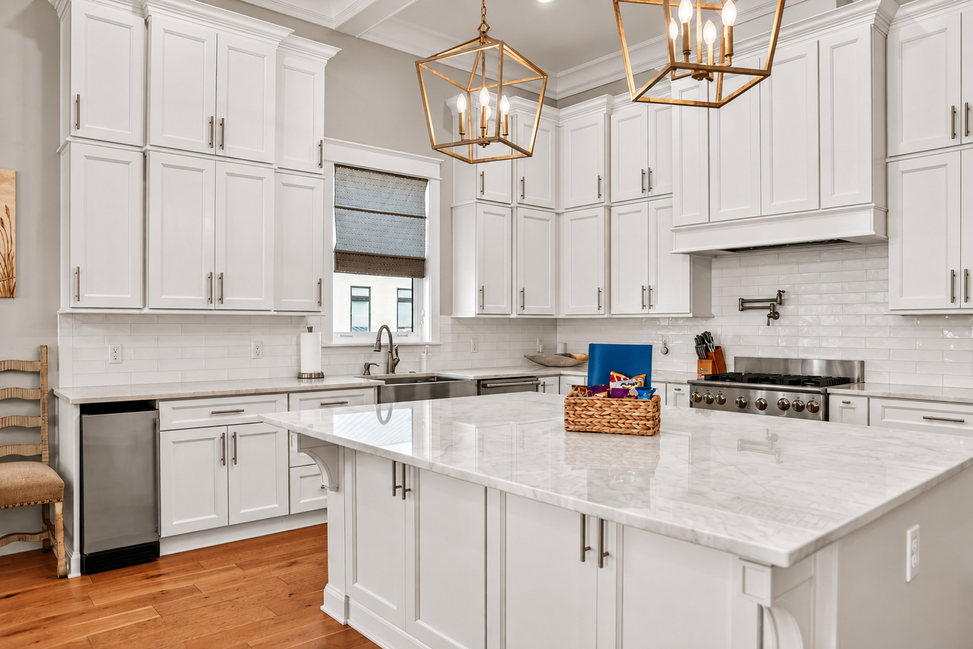 Bright luxury kitchen with oversized island and elegant designer lighting