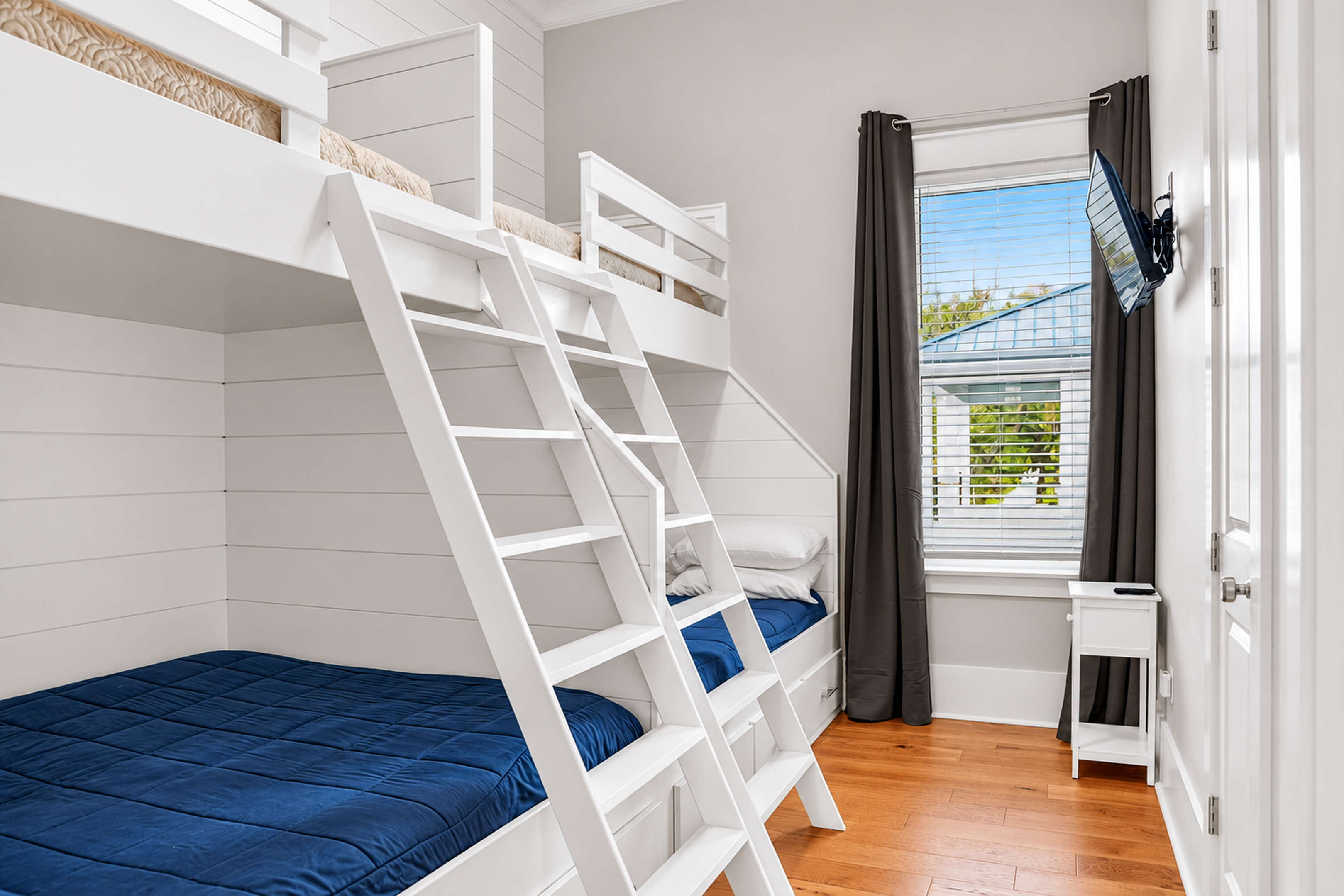 Bright custom bunk room with 4 beds, tall ceilings, and a TV