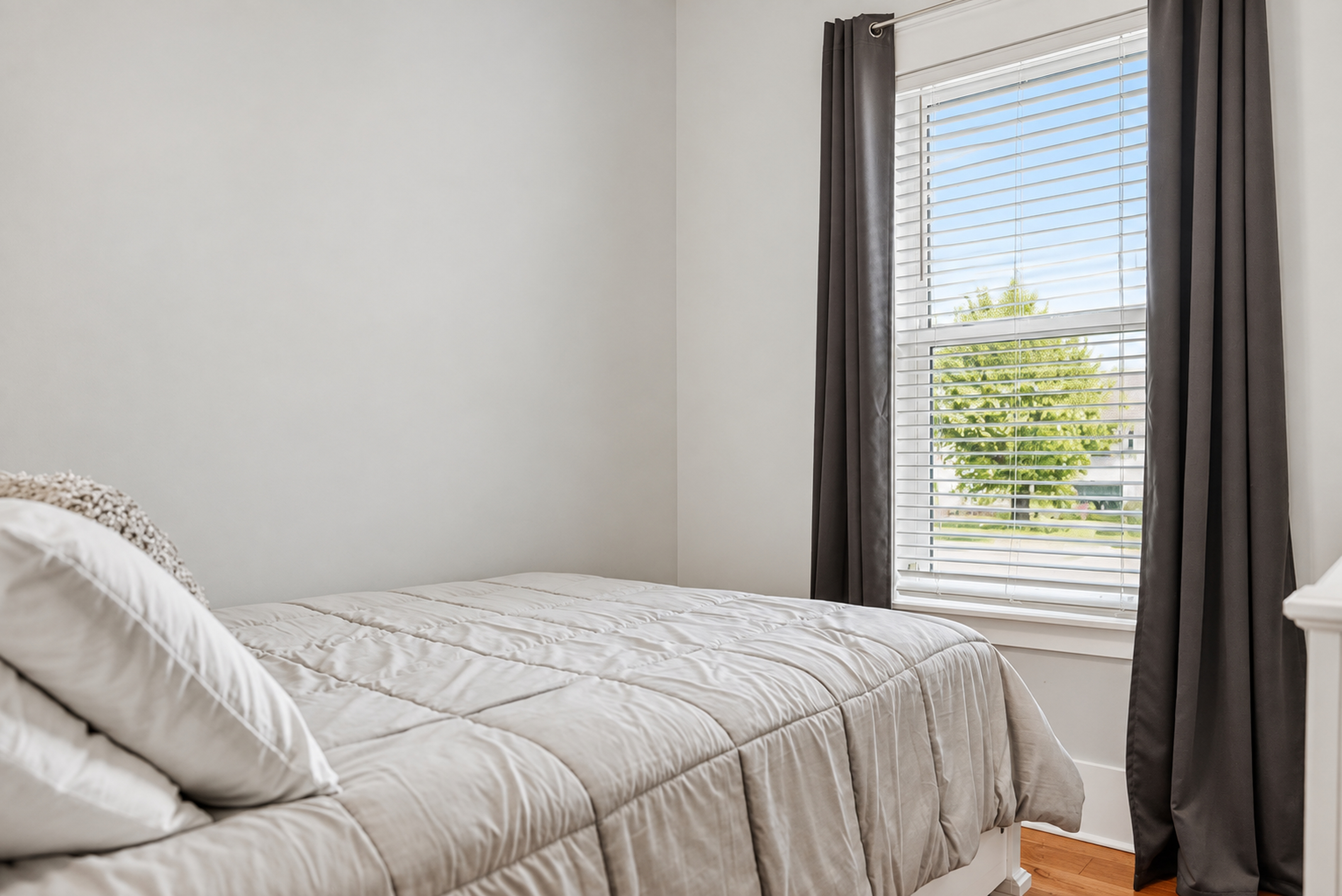 Bright, cozy bedroom with natural light and a peaceful window view