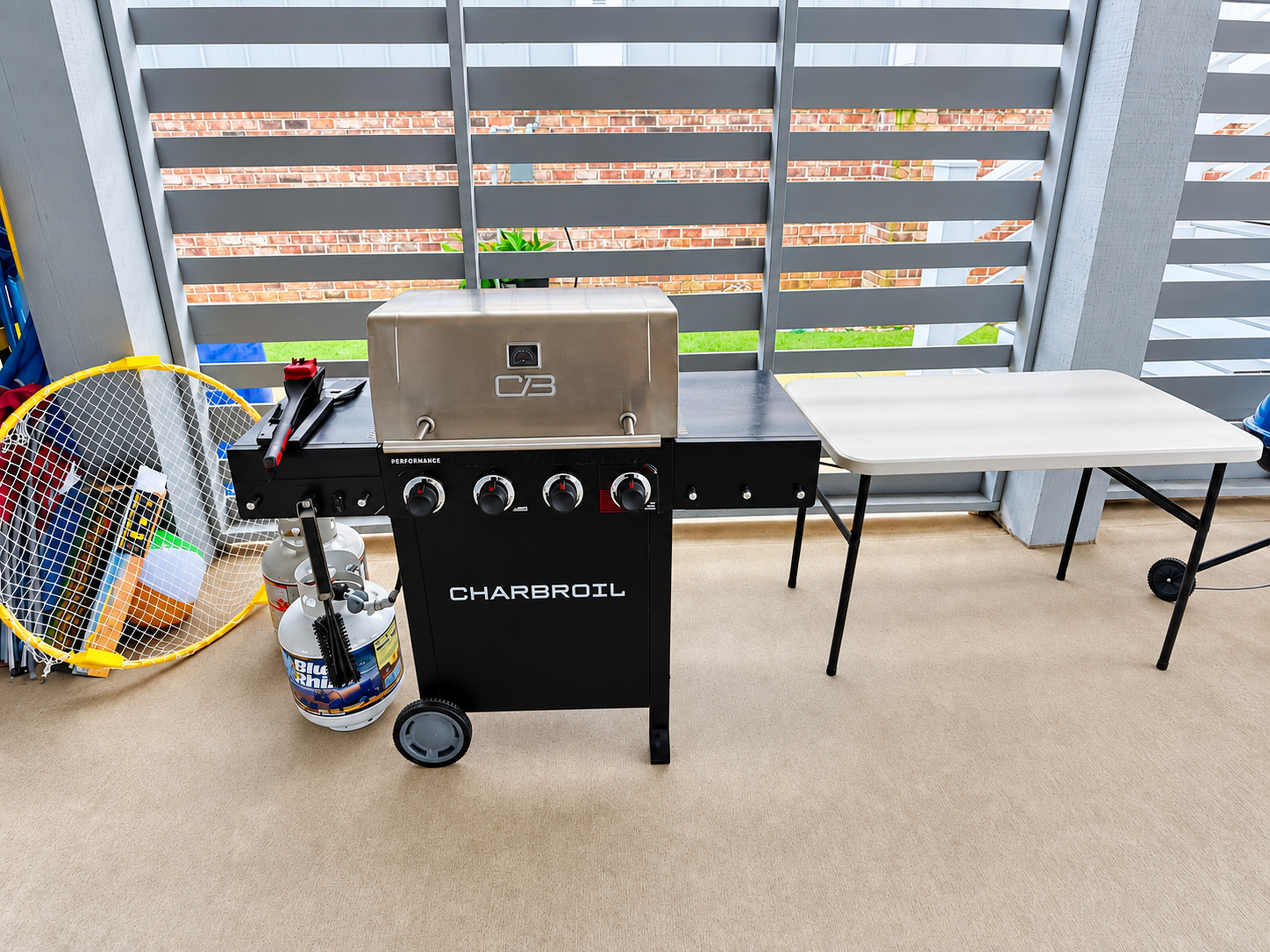 Covered patio with gas grill and prep table for easy outdoor cookouts