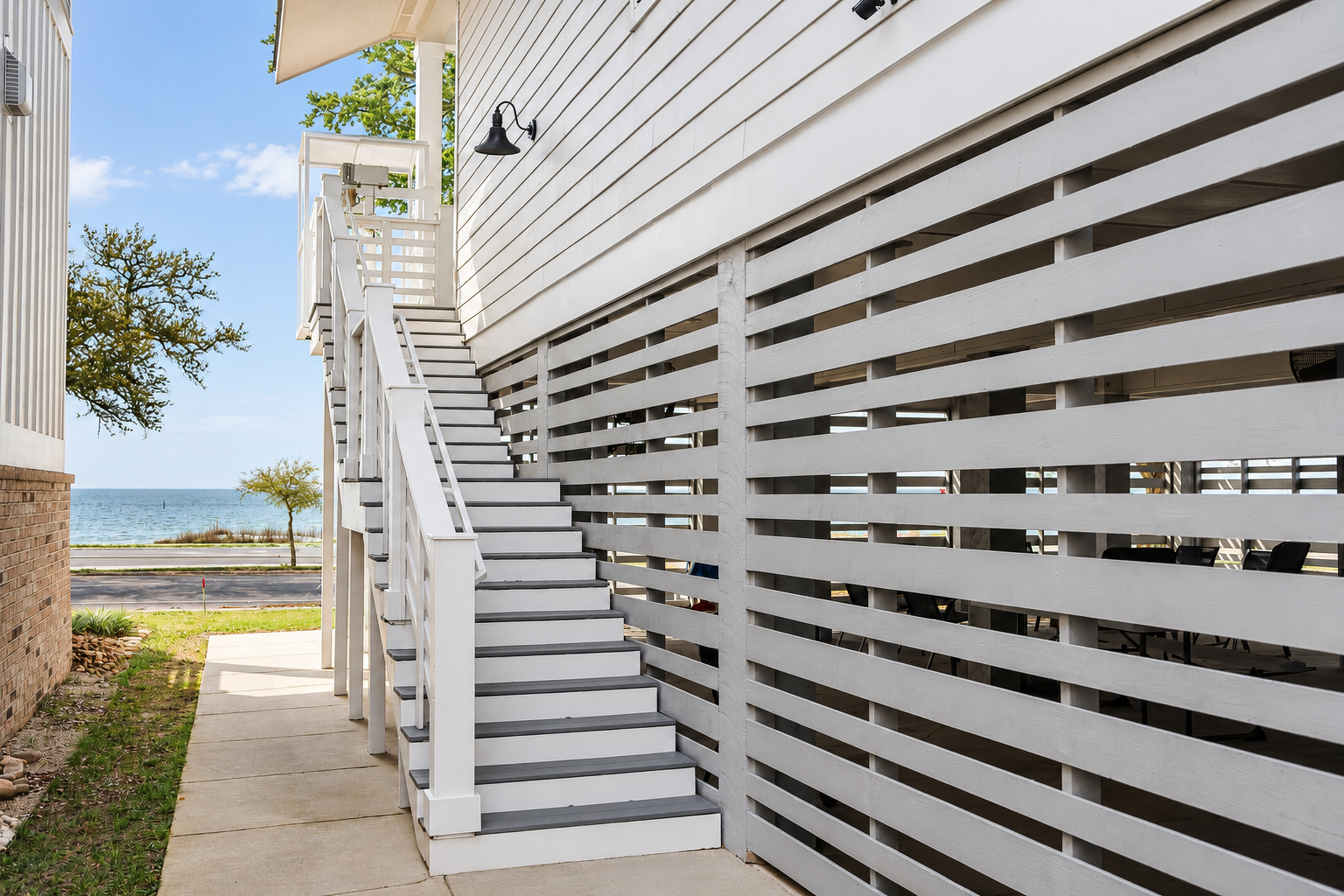Bright coastal entry with private stairs and a peek of the water