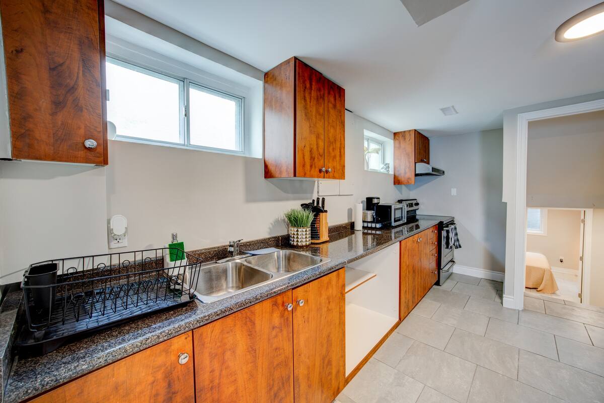 Bright galley kitchen with long counters, wood cabinets, and essentials