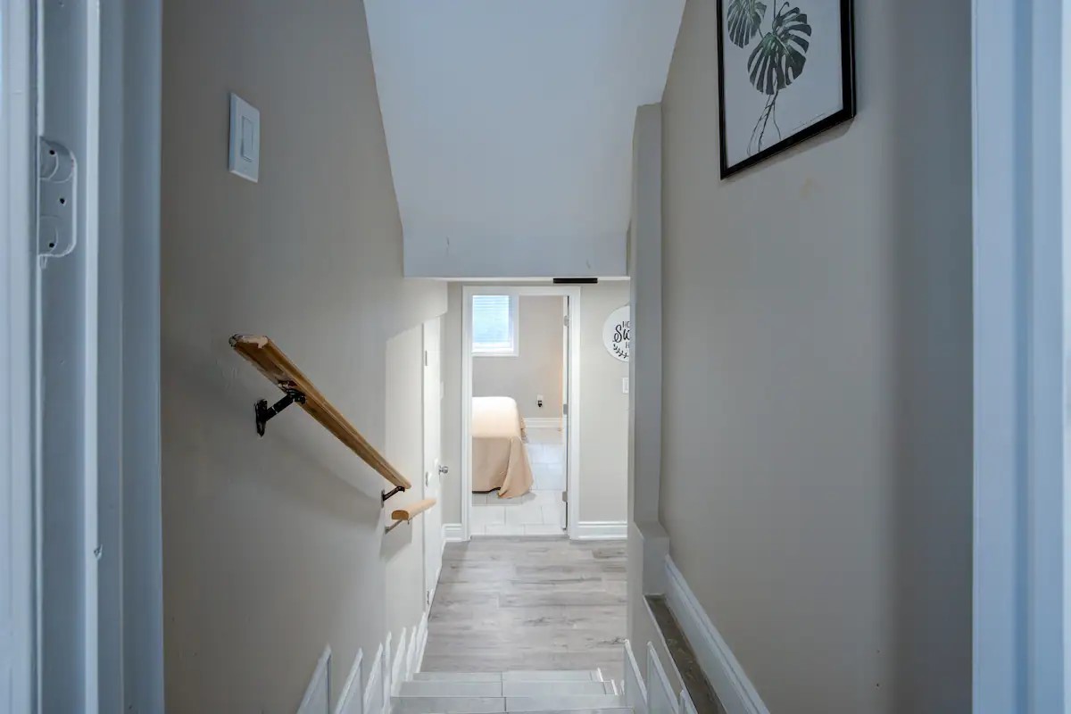 Bright hallway to cozy bedroom with modern, neutral finishes.