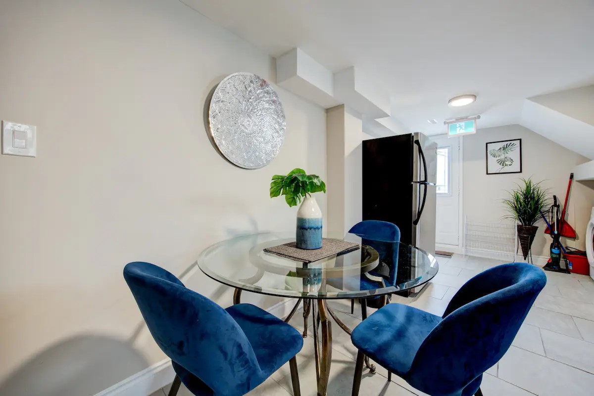 Cozy dining nook with velvet chairs, glass table, and bright entryway