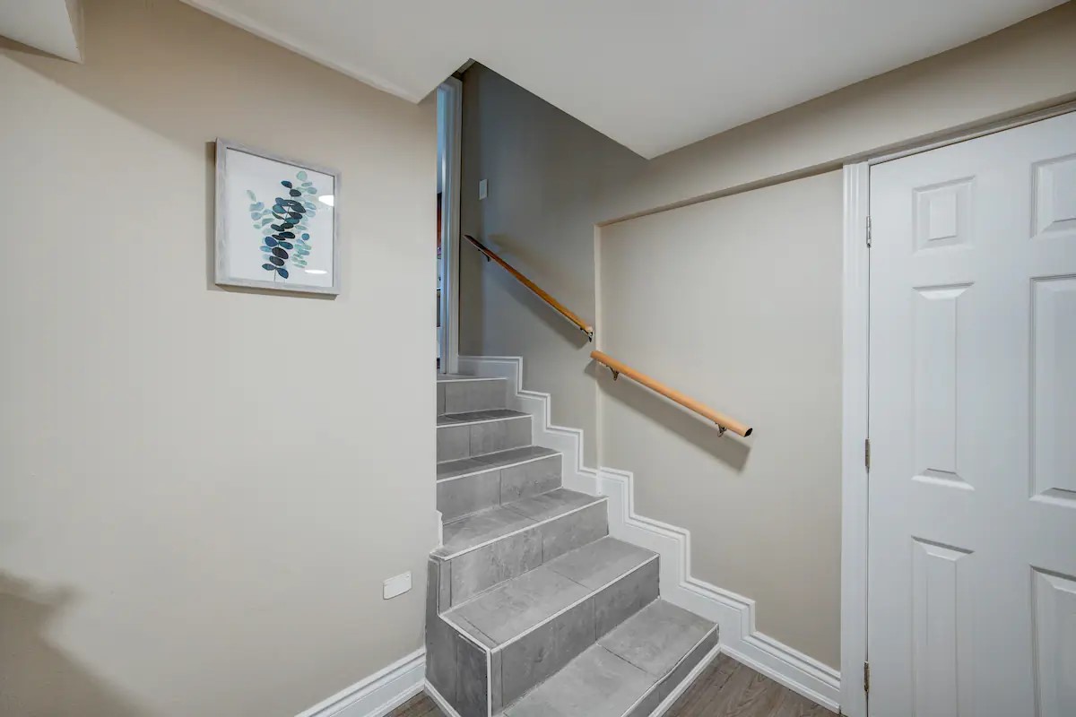 Bright, modern stairway with gray tile steps and secure handrails