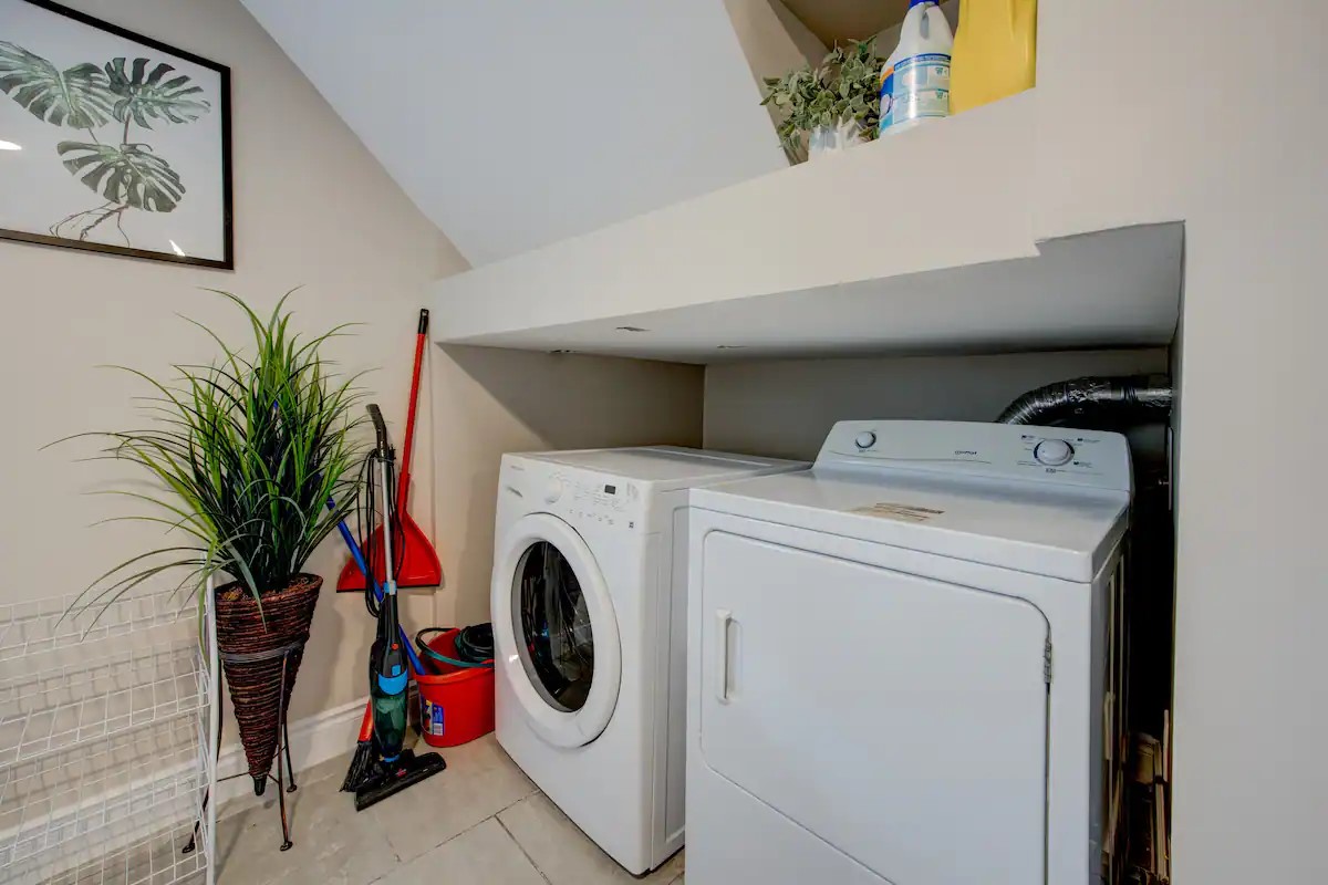 In‑unit washer/dryer and cleaning supplies in a neat laundry nook.