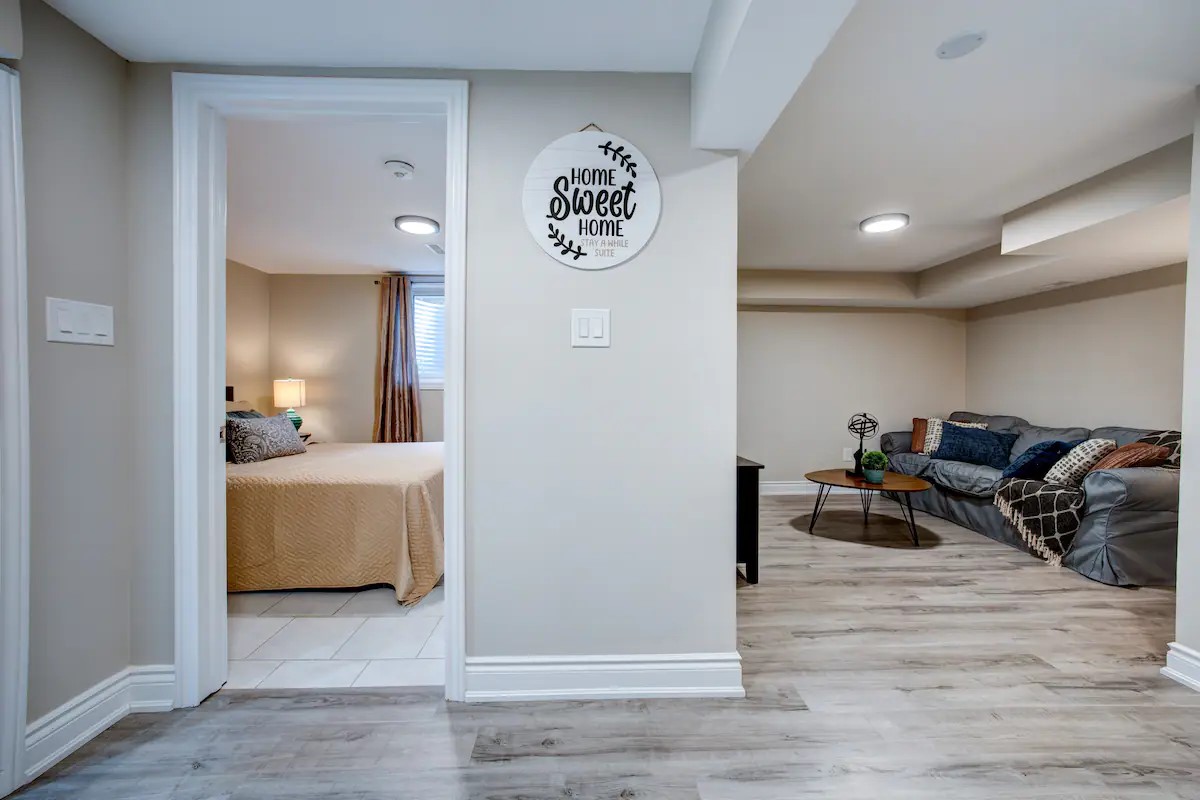 Cozy suite with sectional lounge, bright bedroom, and wood floors