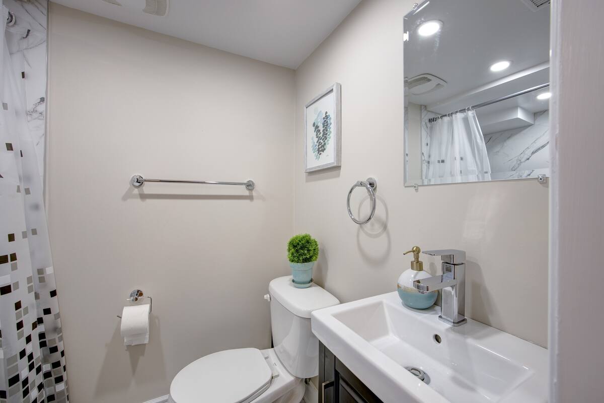 Bright, modern bath with sleek vanity and marble-tiled shower.