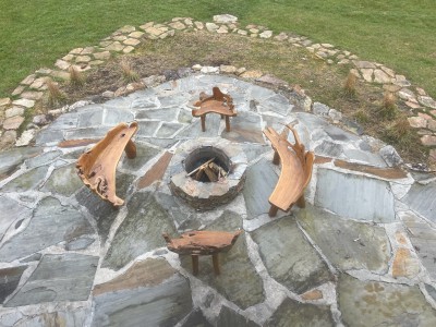 Flagstone fire pit with artisan wood seating—perfect for starry nights.