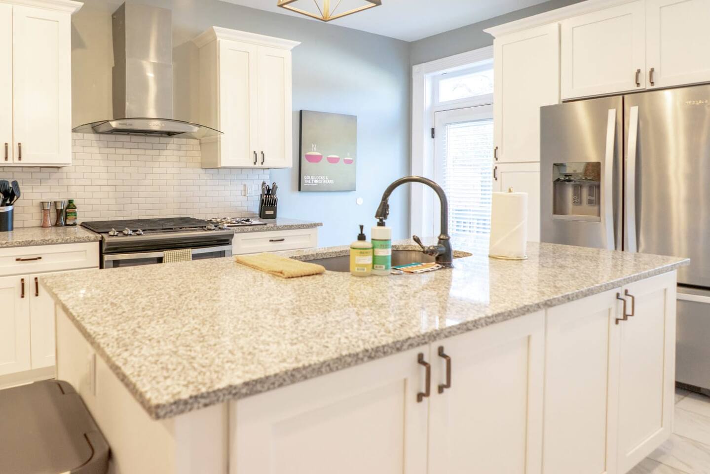 The kitchen features high-end stainless steel appliances and sleek granite benchtops