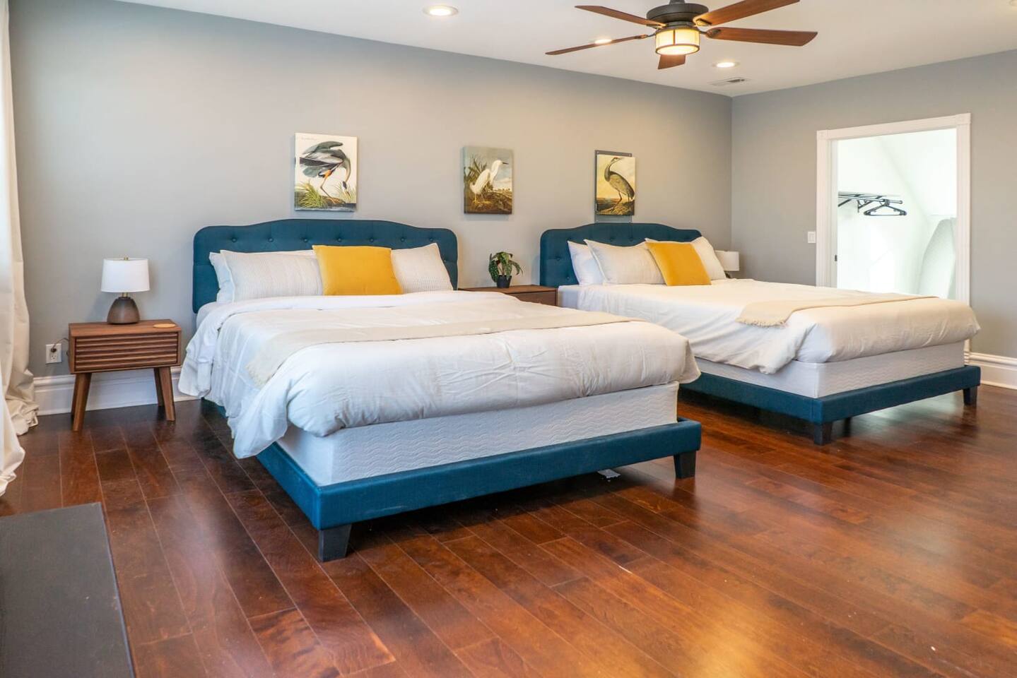 The generous third floor bedroom four with two queen beds, a wall mounted Roku TV and a crib