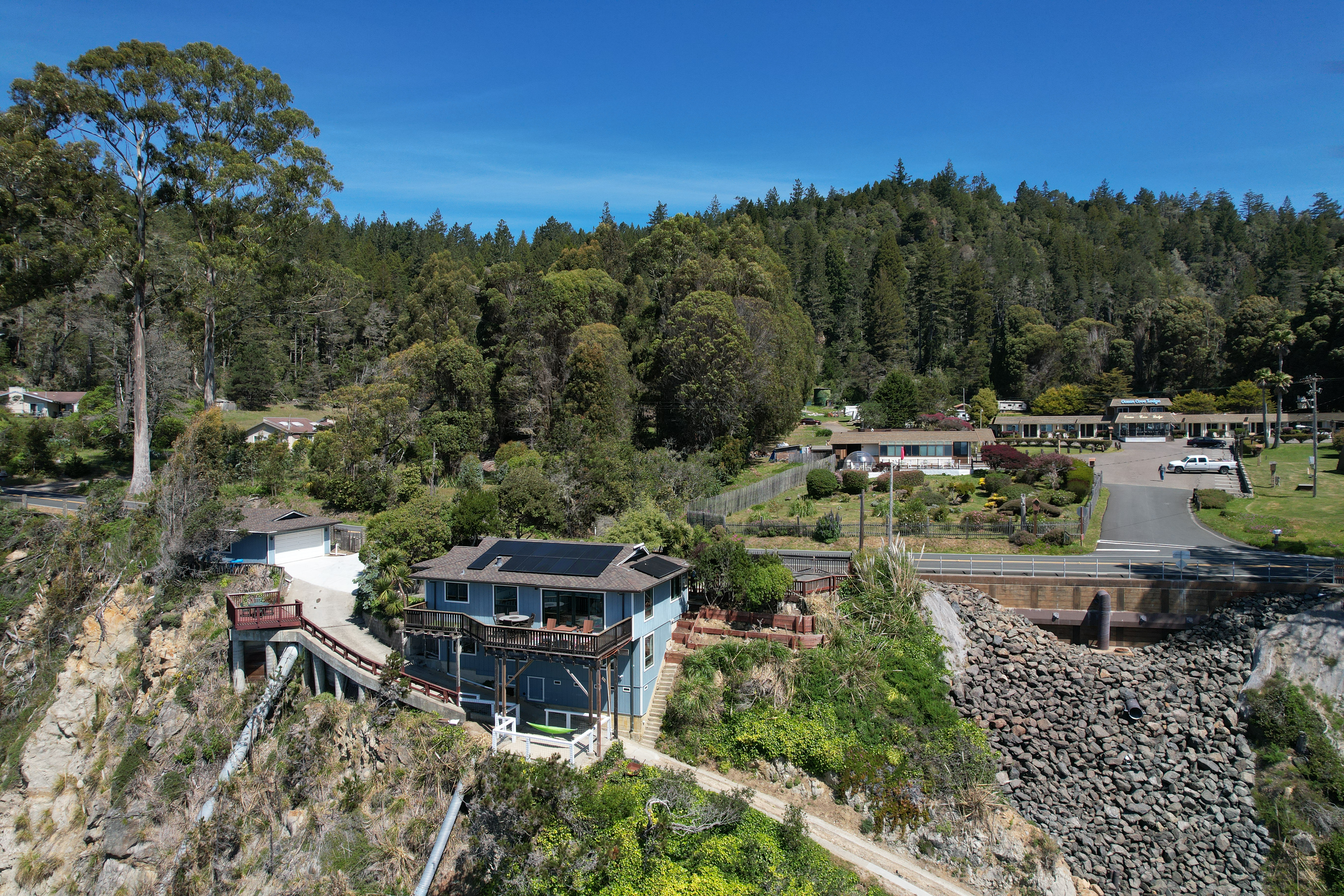 Cliffside retreat with panoramic deck views amid redwoods and water