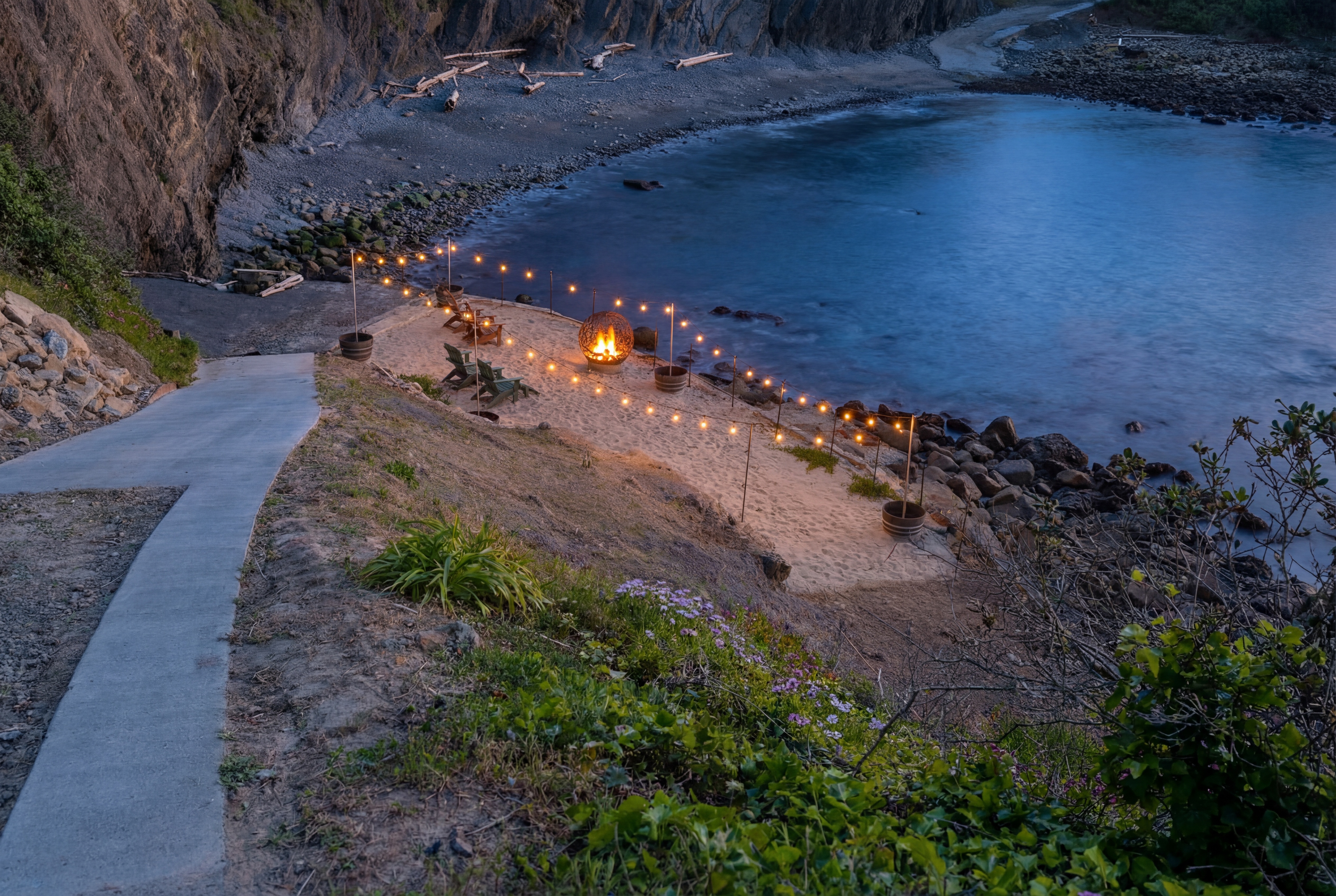 Secluded cove: private beach hangout with fire pit & string lights