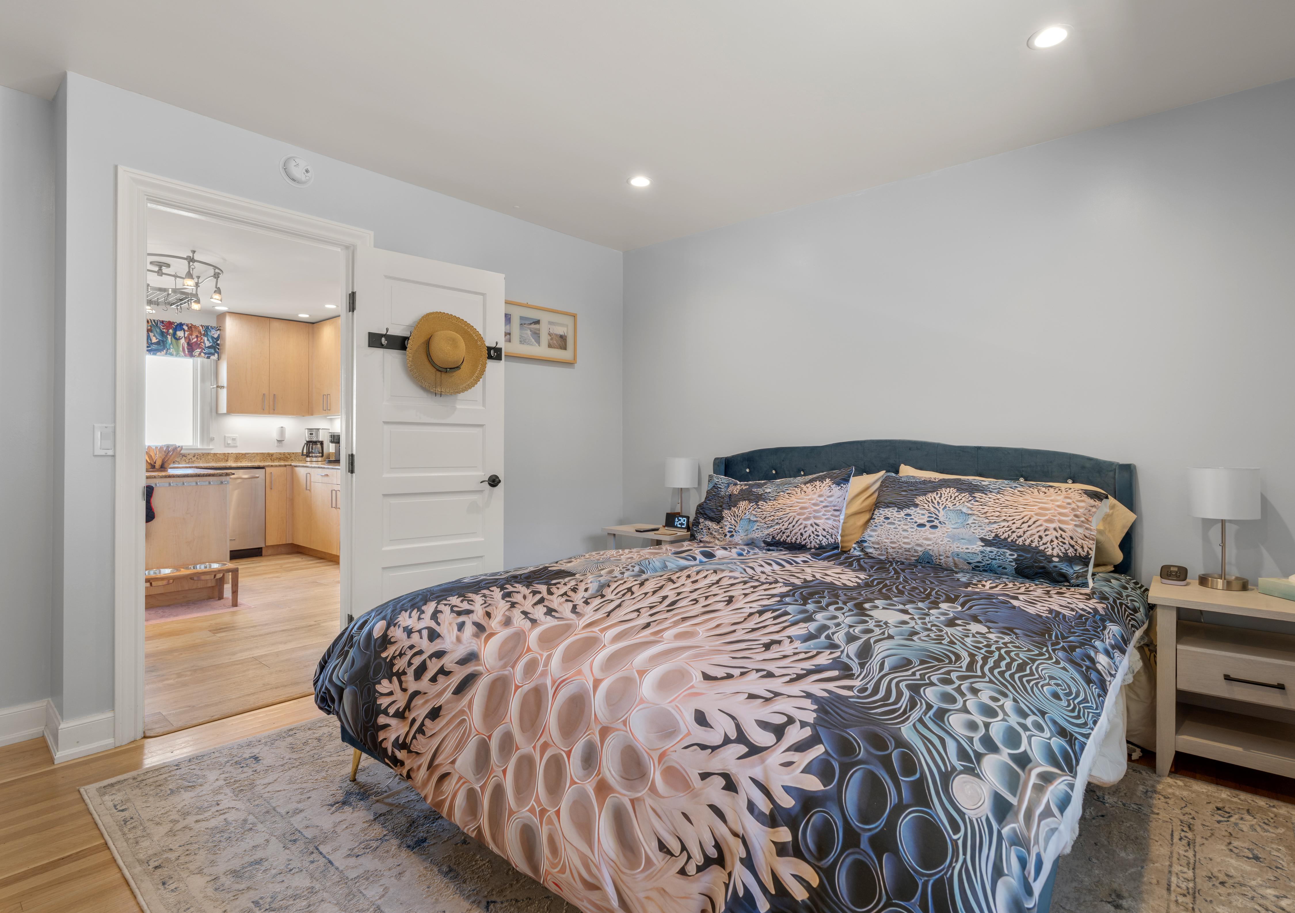 Serene bedroom with stylish bedding and lamps, steps from the kitchen.
