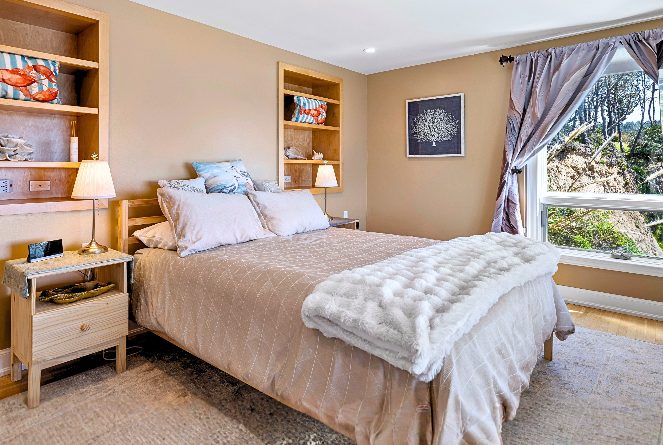 Cozy, sunlit bedroom with plush bedding and peaceful nature views