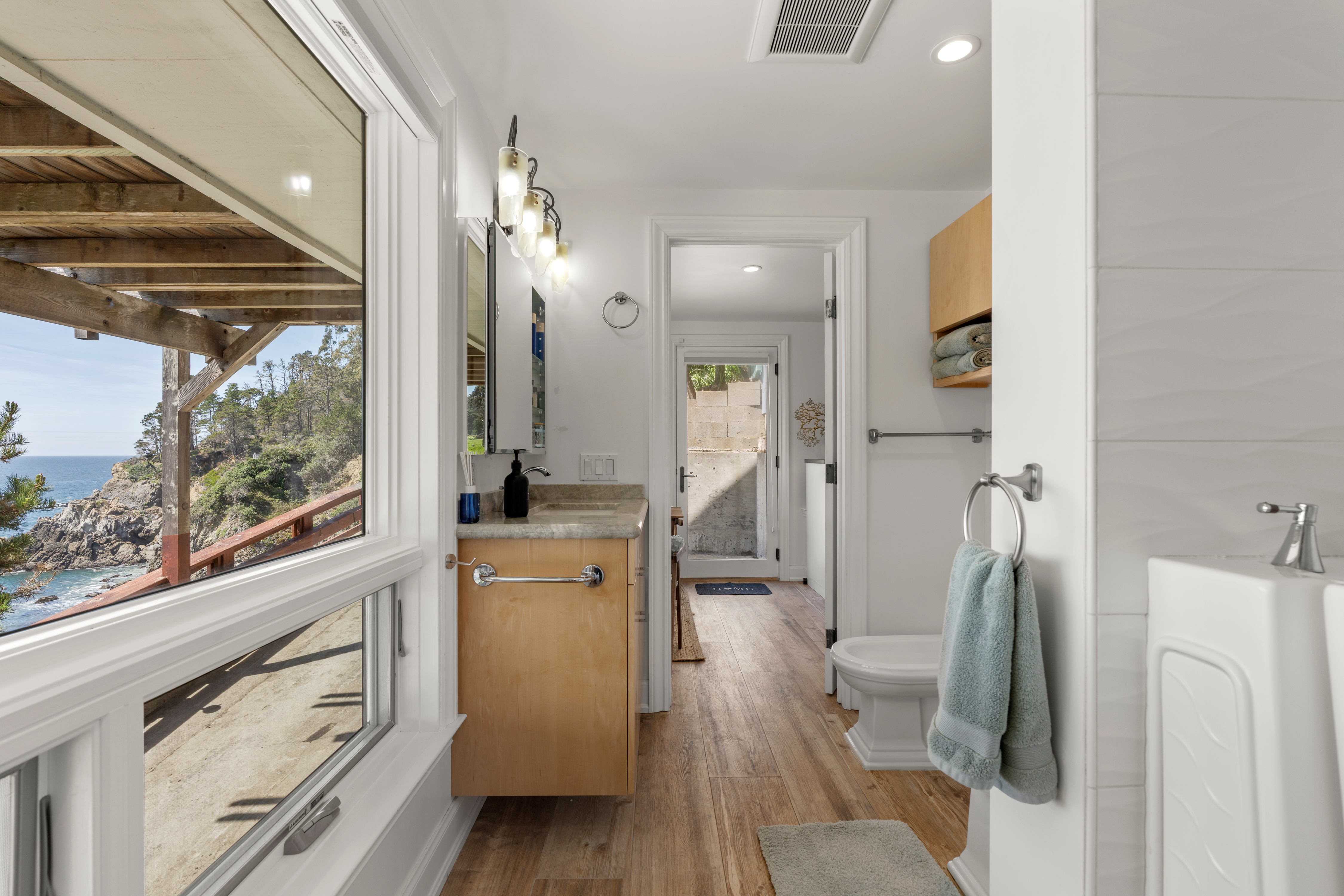 Bright ocean-view bathroom with modern vanity and beachy finishes