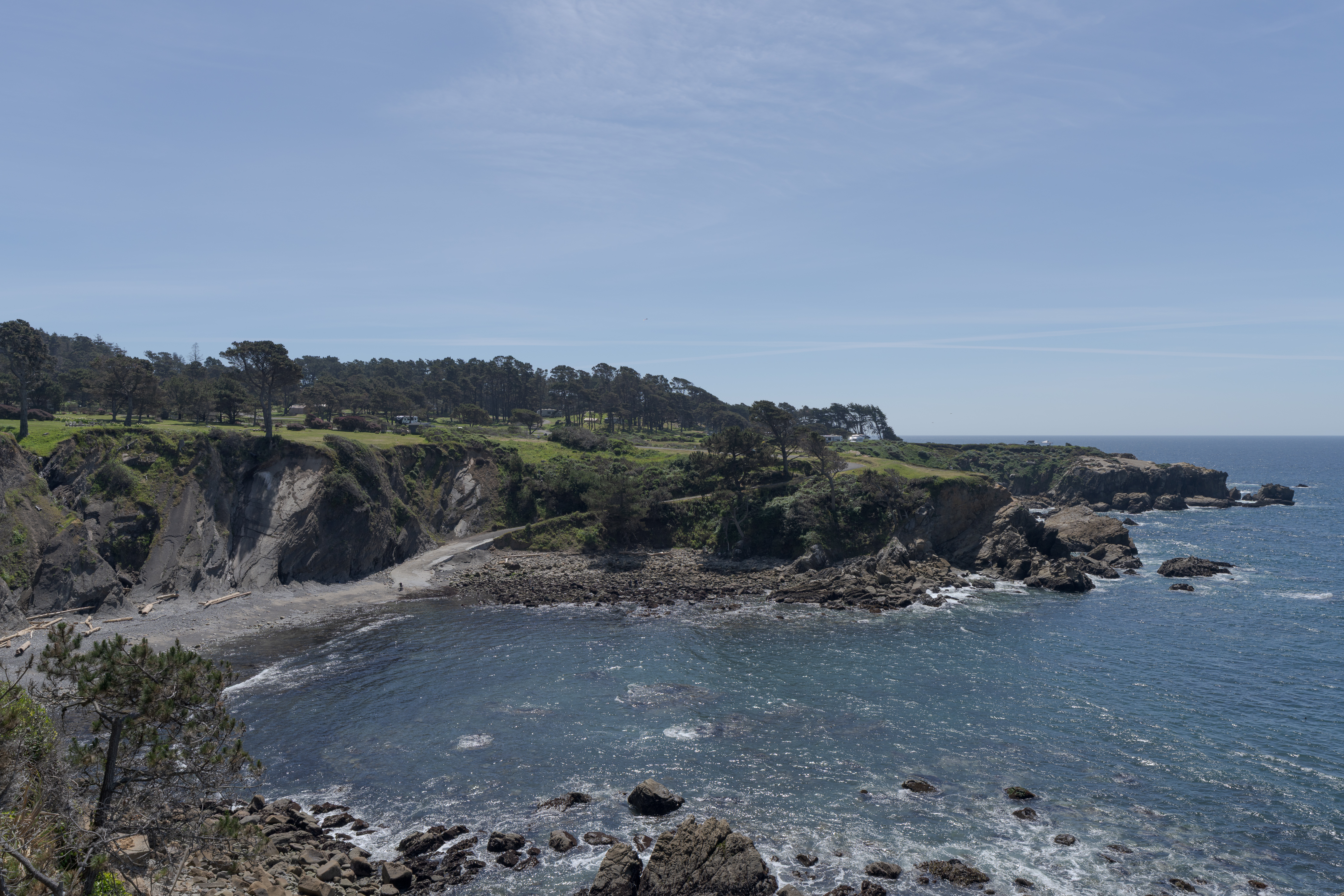 Rugged ocean cove views—cliffs, small beach, and serene blue waters.