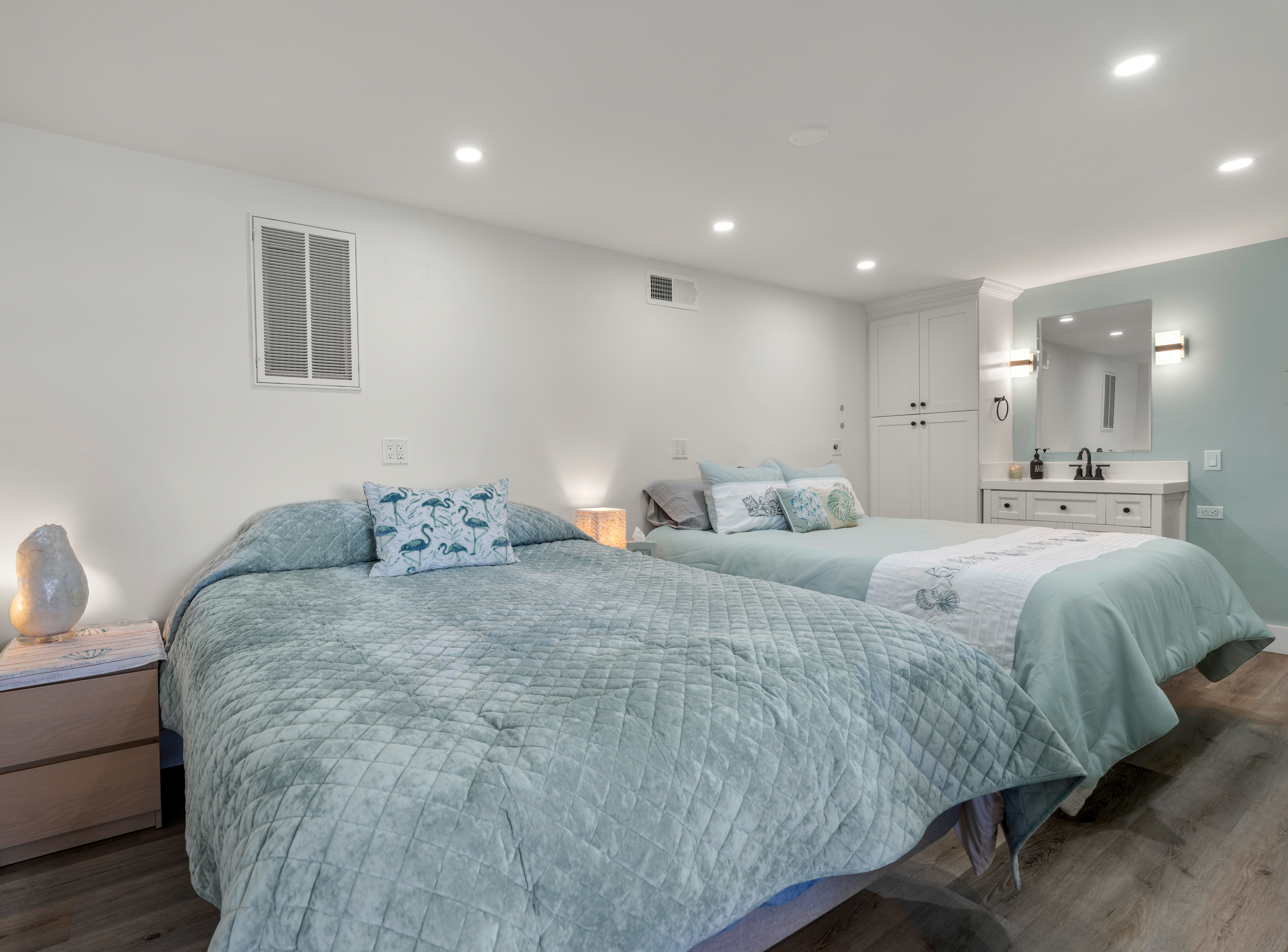 Bright room with two queen beds, wood floors, and in-room vanity.