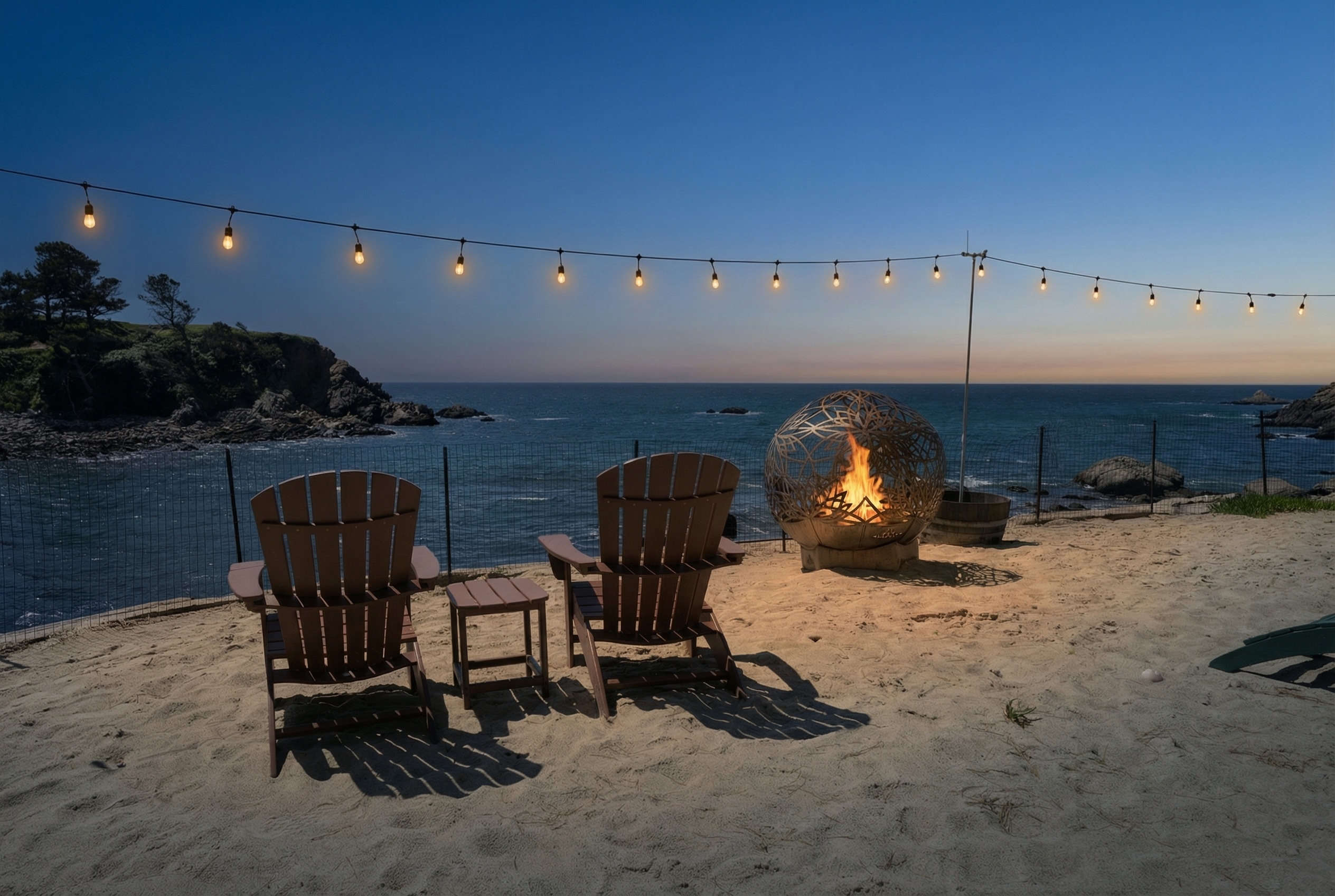 Oceanfront patio with sculptural fire pit and sunset views