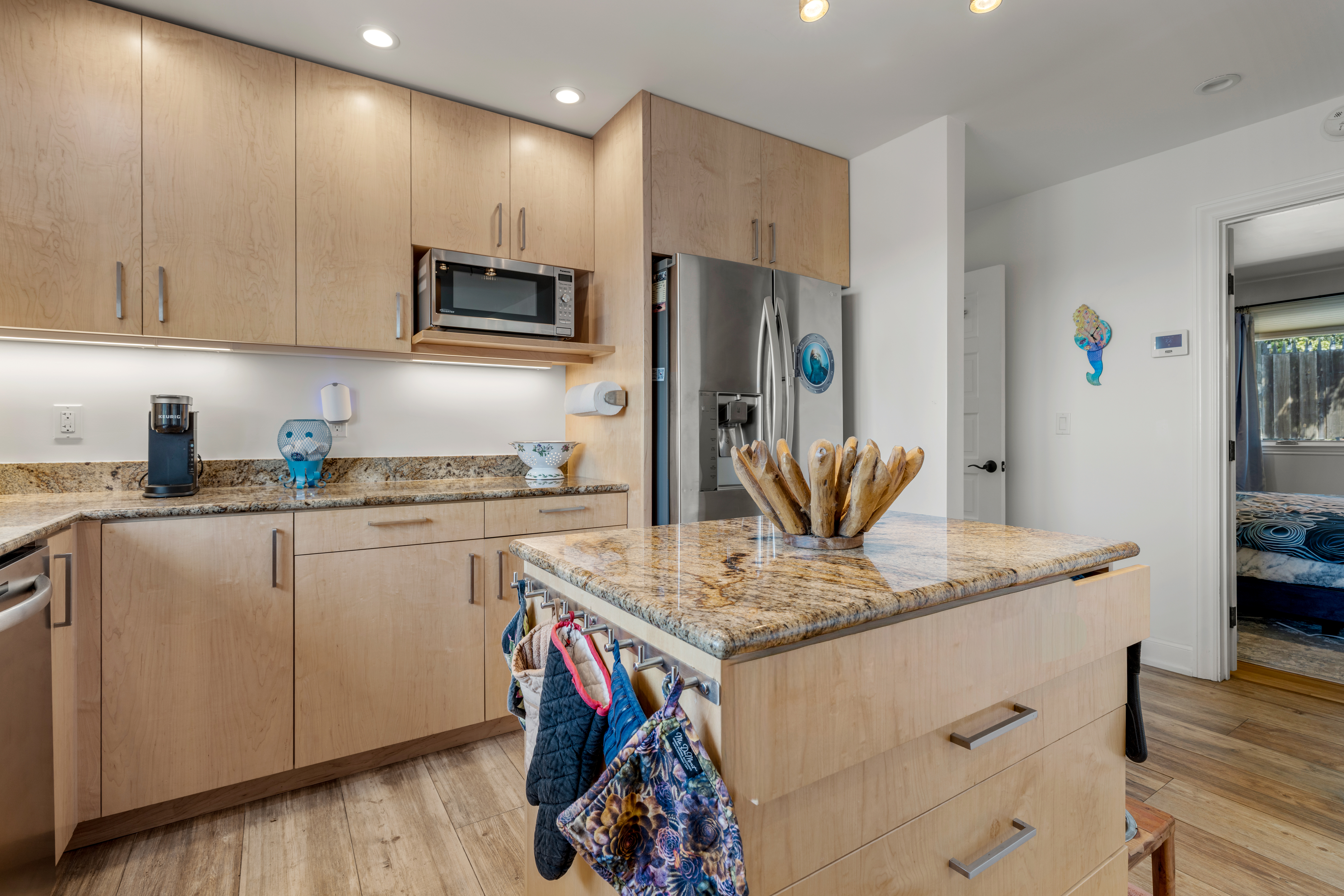 Bright kitchen with granite island, stainless appliances, coffee bar