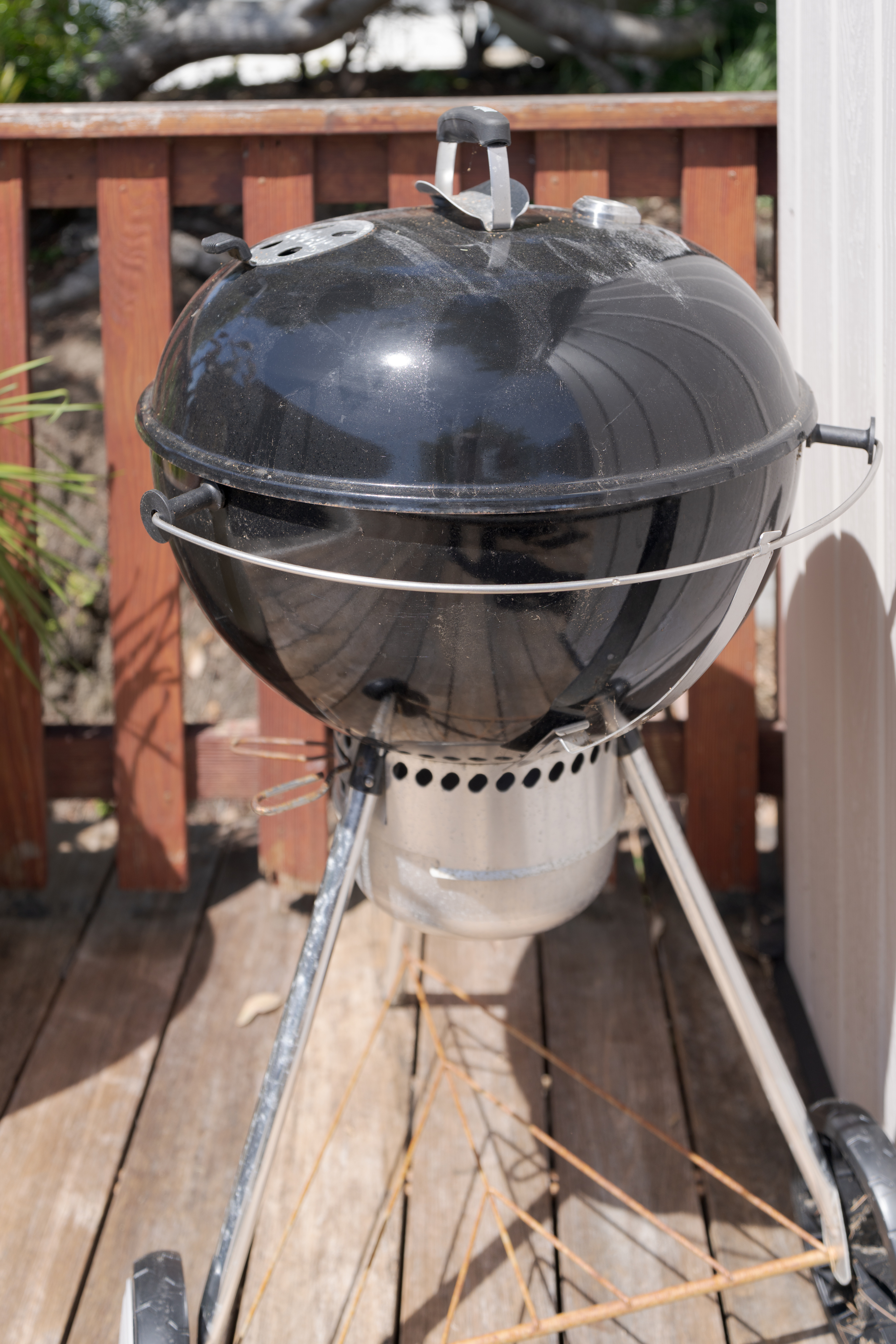 Charcoal kettle grill on sunny deck—perfect for backyard BBQs